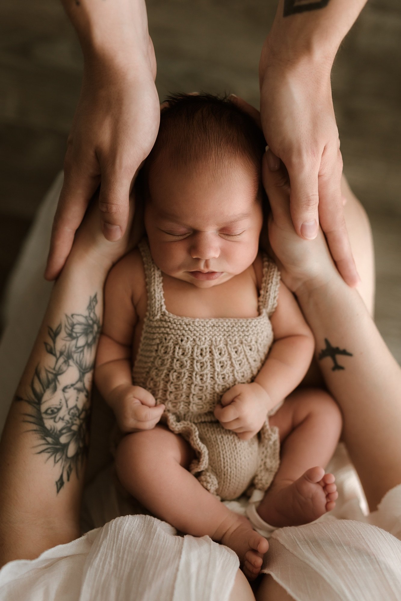 Miminko spí v náručí rodičů při novorozeneckém focení v Olomouci