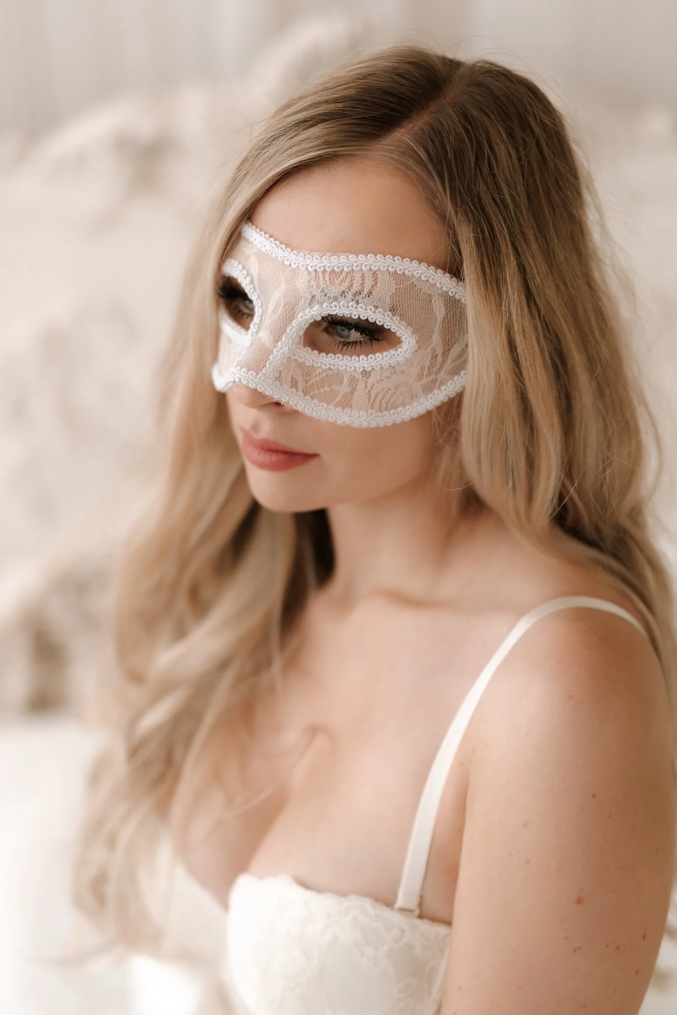 Žena v prádle má na obličeji krásnou krajkovou masku při boudoir focení v Olomouci