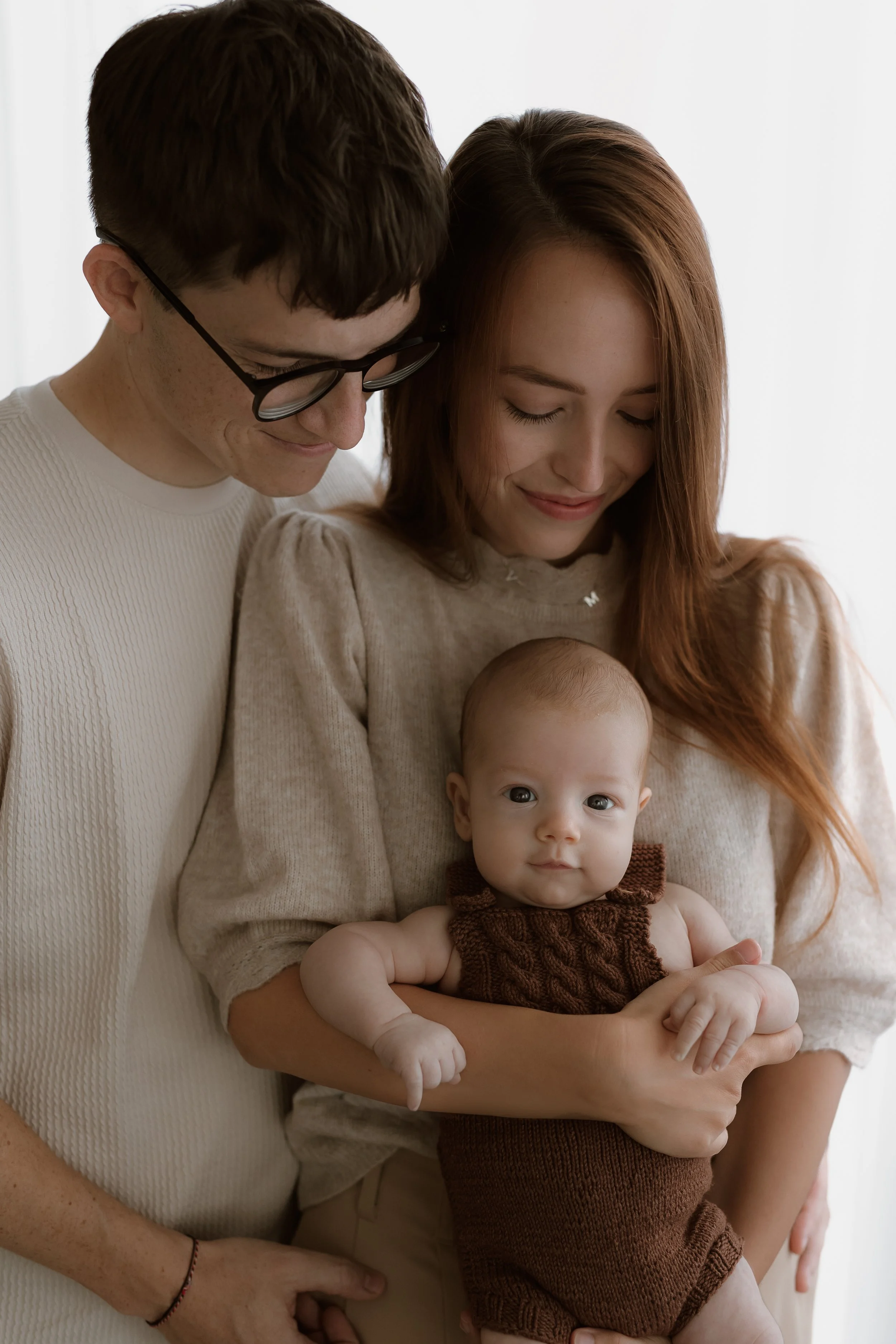 Novorozenec v náručí maminky při newborn focení v Olomouci