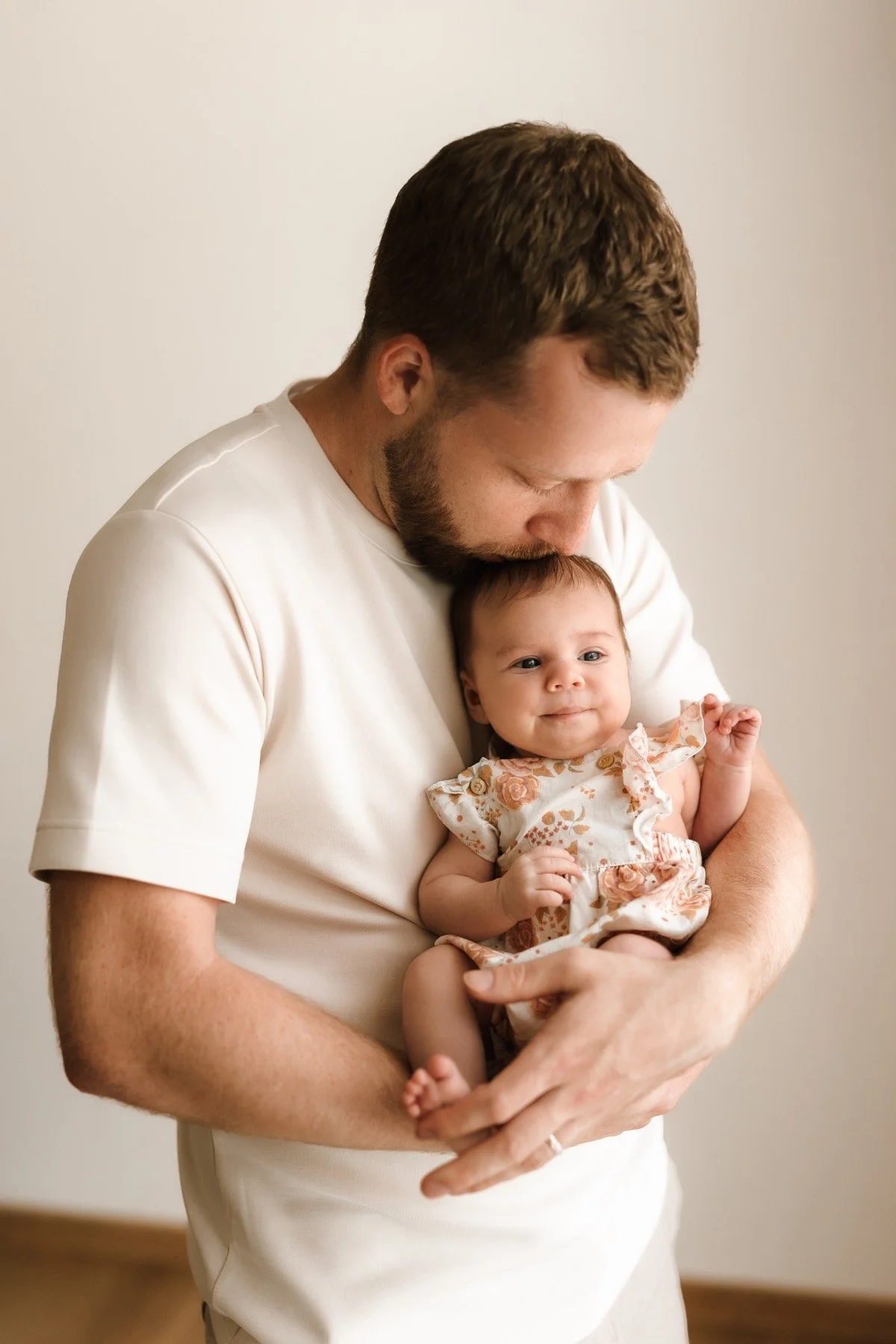 Newborn focení doma - tatínek drží svou dceru při newborn focení doma