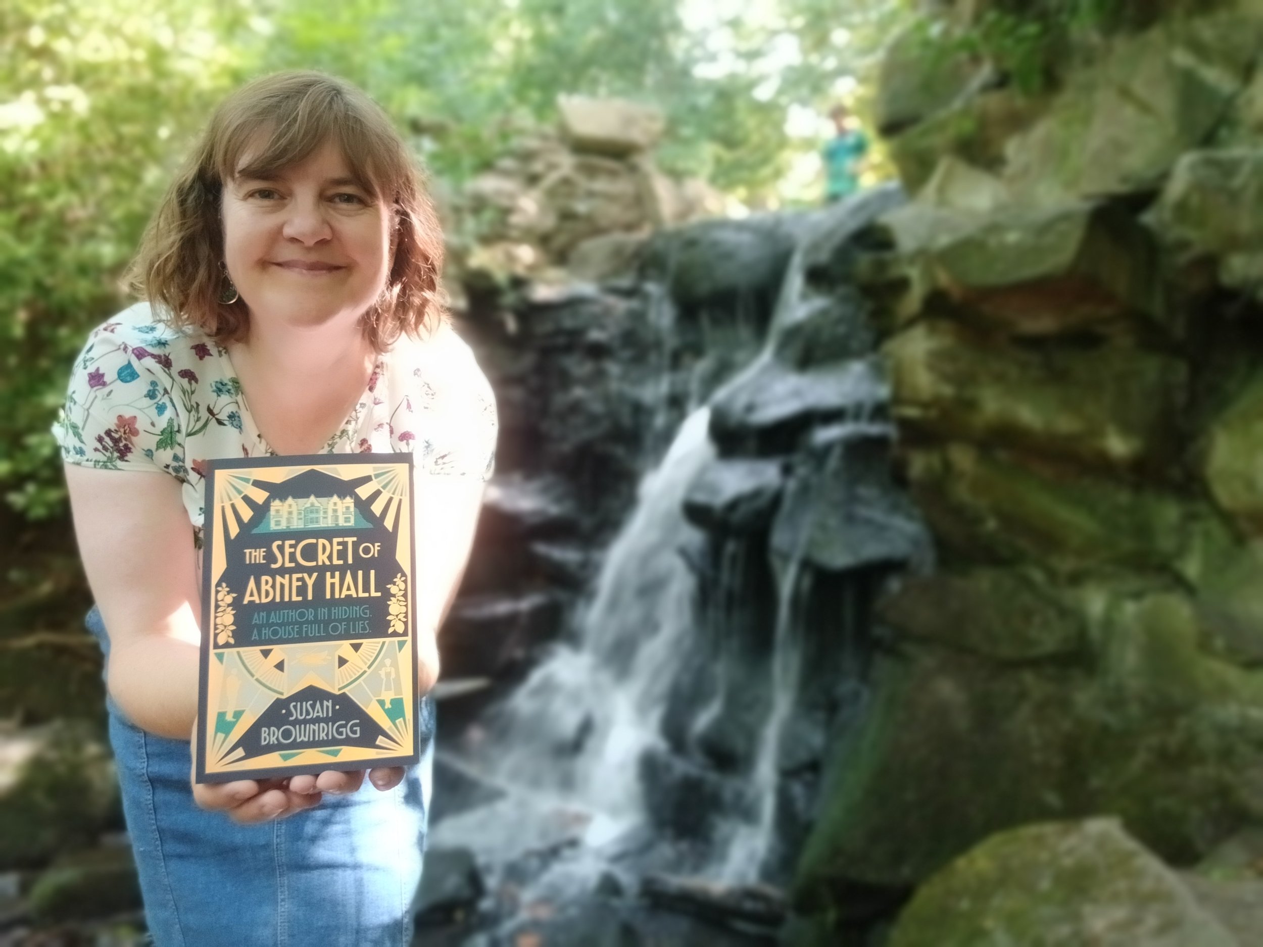 Susan with book at waterfall Abney Hall A.jpg