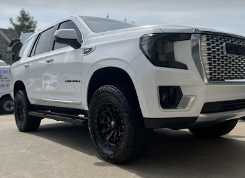 White pickup truck parked outdoors, with black wheels and a black grille.