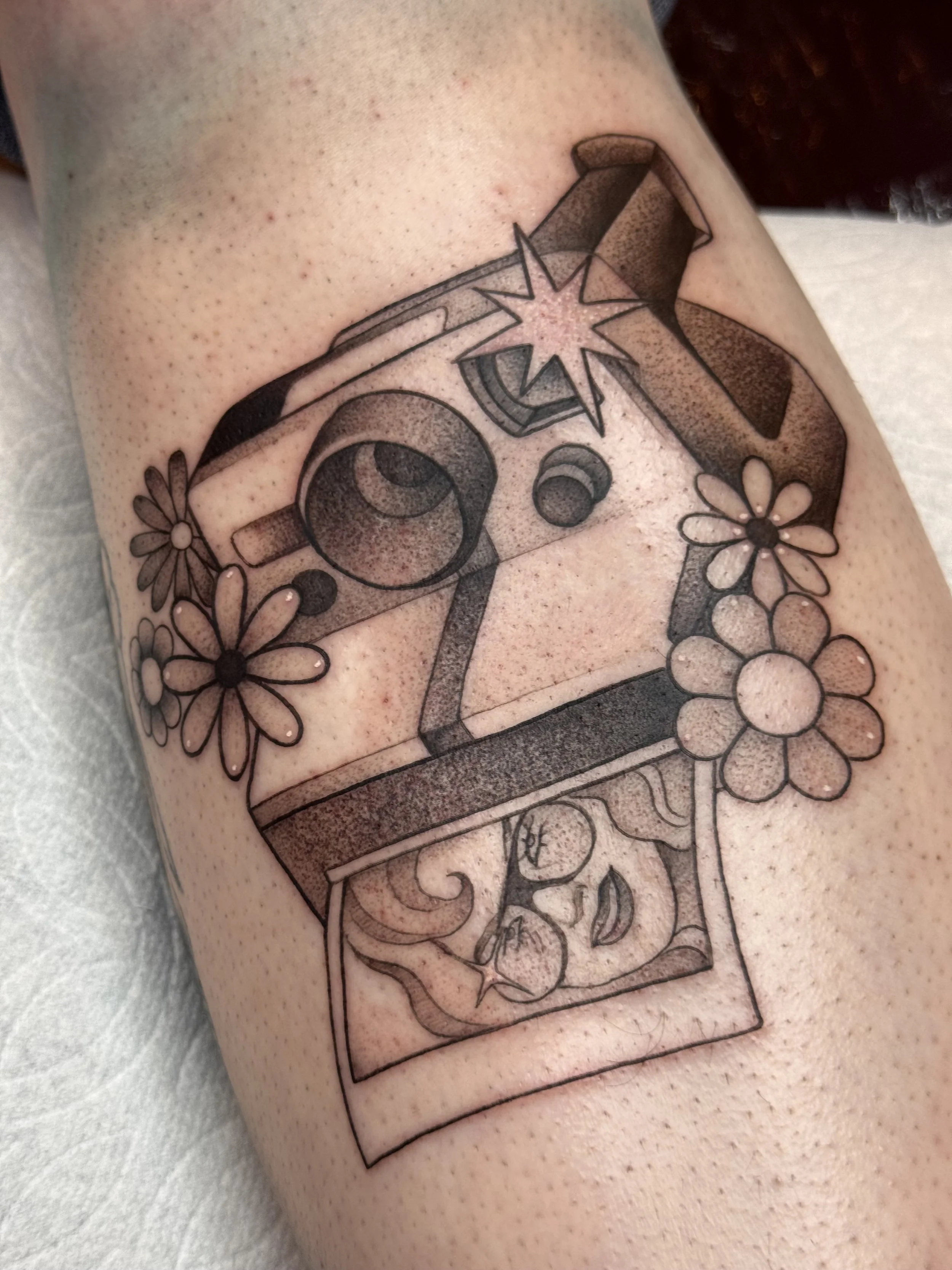 Neotraditional stipple shading polaroid tattoo with groovy flowers