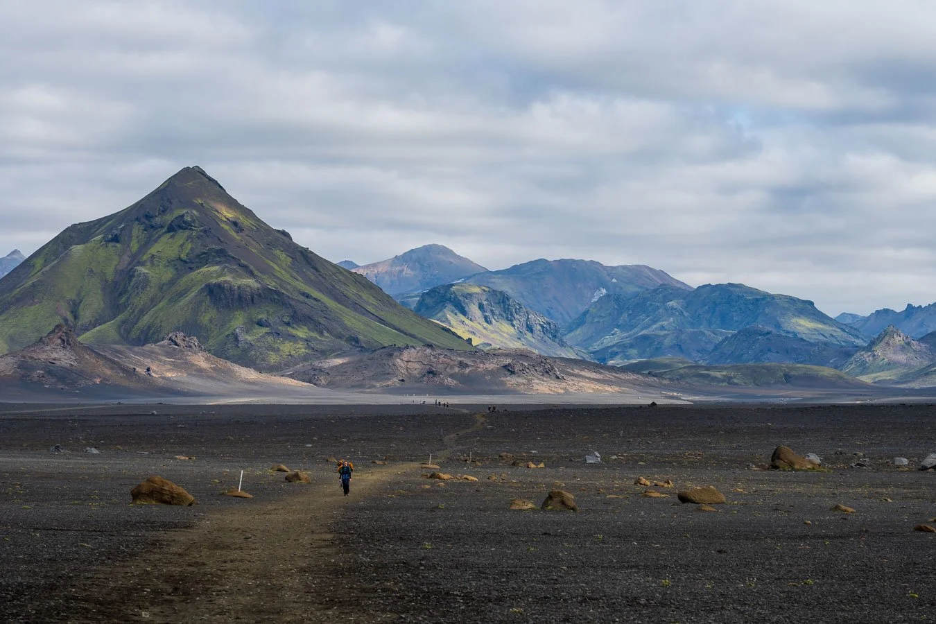  Epic scenery unfolds along the horizon while walking through the vast black sand desert. 