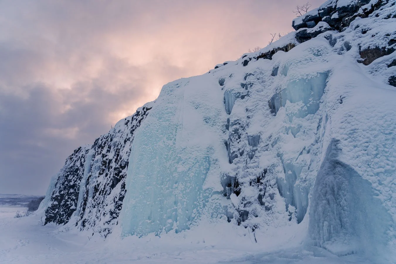 Frozen waterfall in Abisko National Park, Swedish Lapland, frequently used for ice climbing activities in winter.