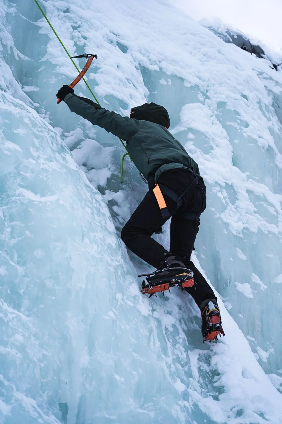 Climber ascending a frozen waterfall during an ice climbing excursion in Abisko National Park, Swedish Lapland, northern Sweden.