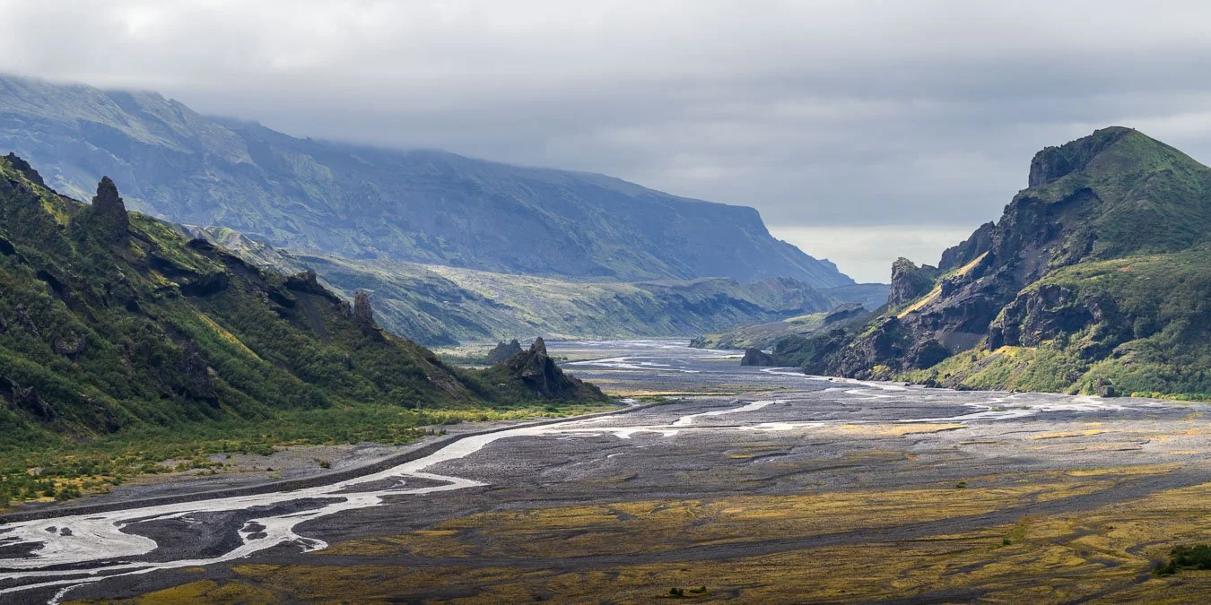 The Krossá river winding through the dramatic mountain ridges of Þórsmörk under striking light, captured along the Laugavegur trail in Iceland’s Highlands.