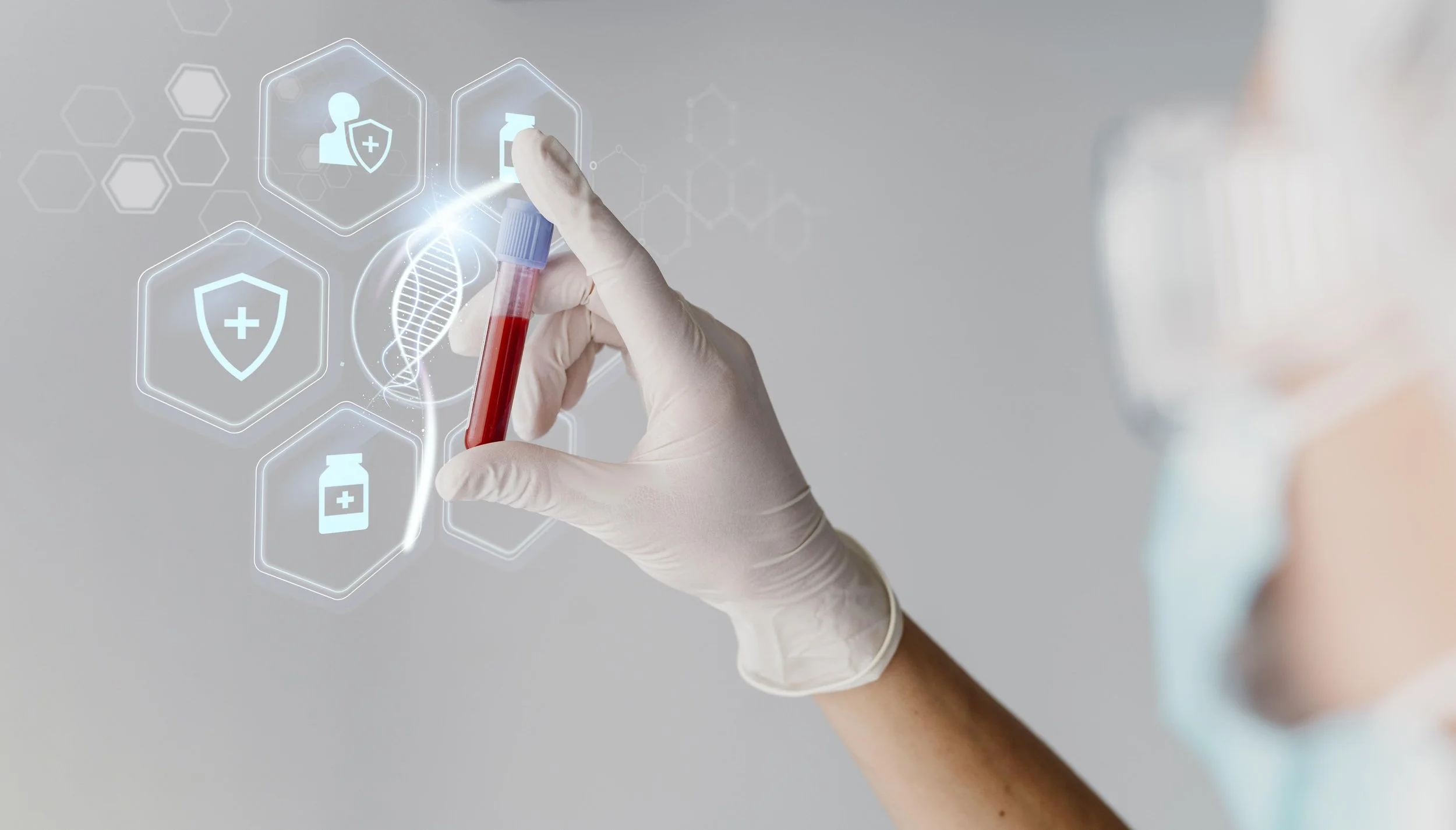 Person in lab coat and gloves holding a test tube with blood, with digital overlay of medical icons and DNA strand.