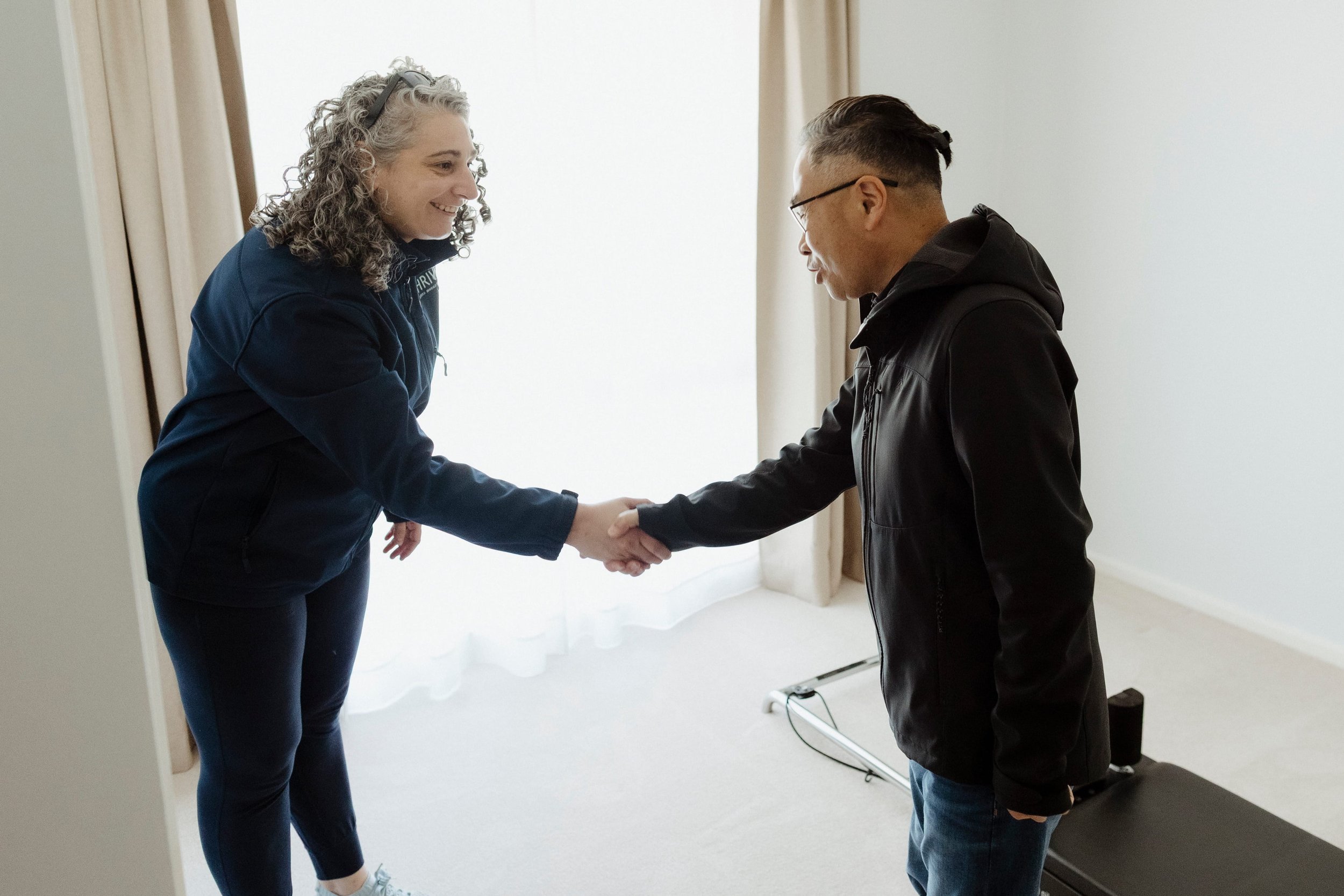 Physiotherapist completing a home-based balance assessment with an older adult