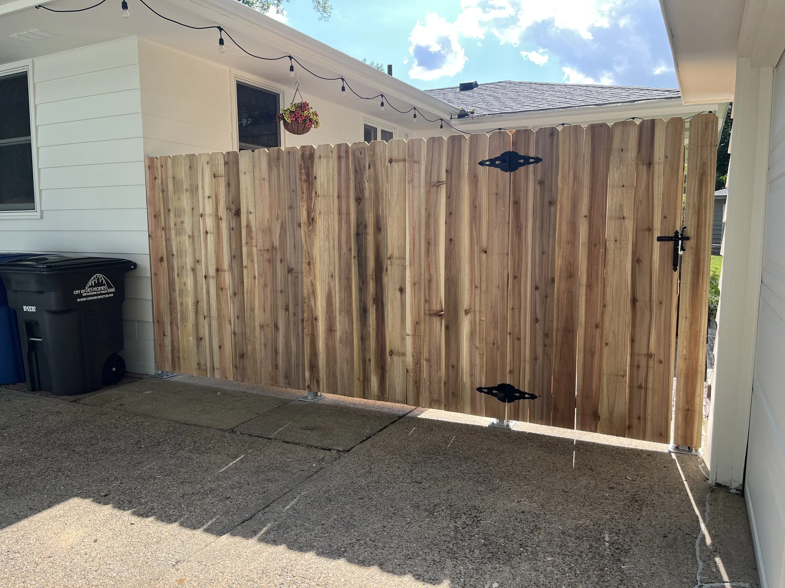 6-foot cedar privacy fence installed on a patio using a plated mounting application, complete with a matching walk gate and strap hinges. This setup provides privacy, durability, and a clean, finished look.