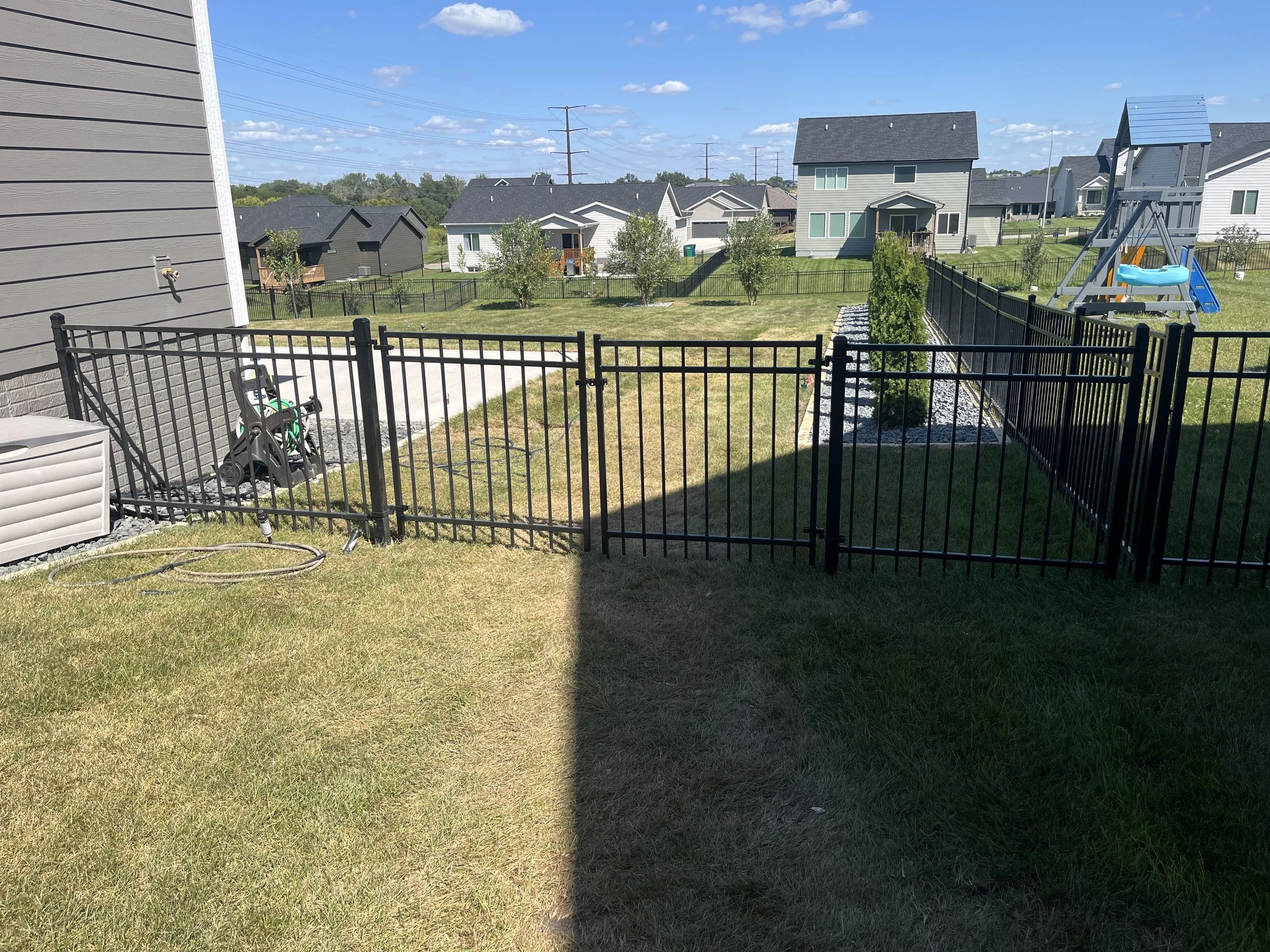 4-foot steel ornamental fence installed in Urbandale, Iowa, manufactured by AFS and featuring a double drive gate. This installation provides durable security with a clean, professional appearance.
