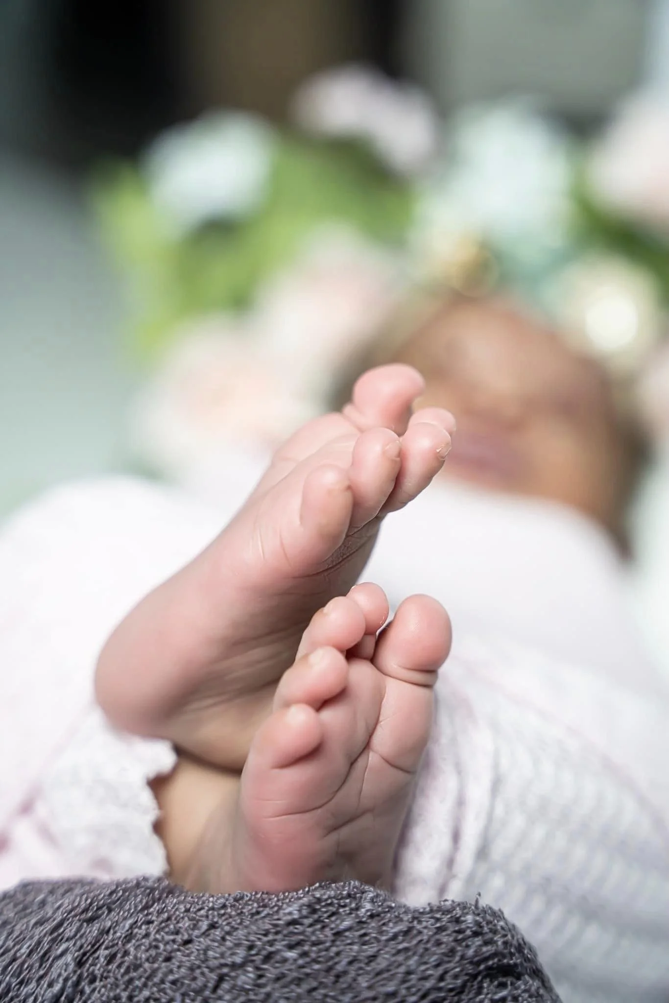 Close-up of a child's hand reaching out, with a child's face in the background, slightly blurred, wearing a white shirt and dark-colored pants.