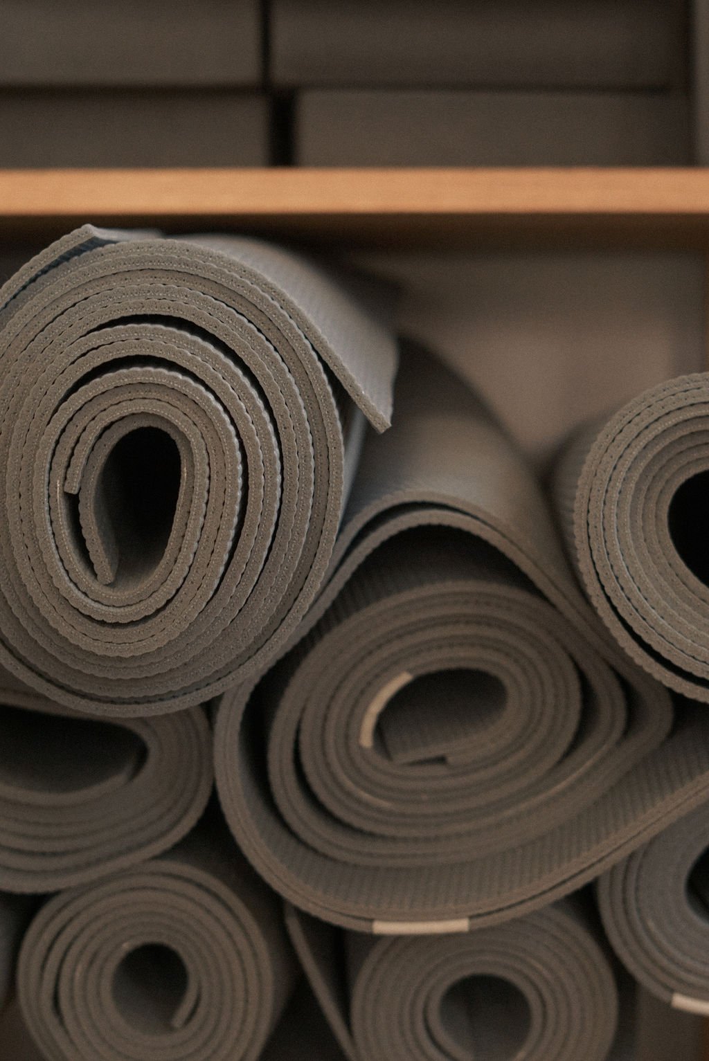 Rolled up grey yoga mats in a Pilates studio, representing fitness content and virtual assistant support for digital products, content marketing, and SEO for movement professionals.