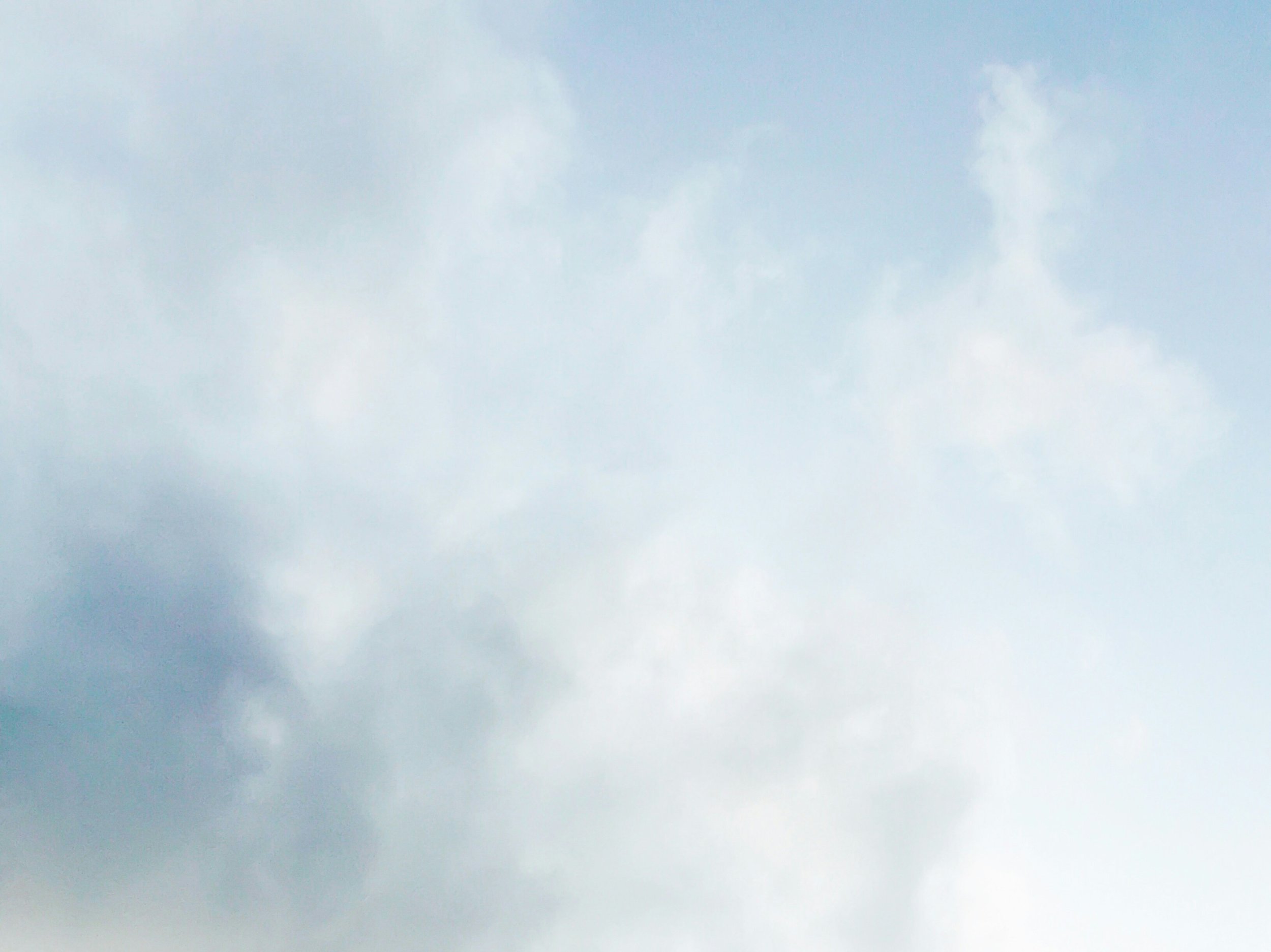 A muted, hazy wash of blue and white cloud, soft and settled