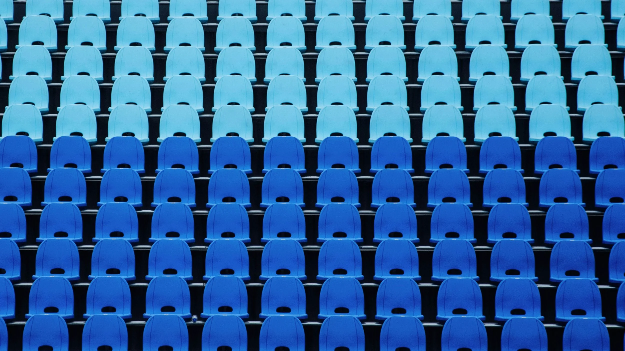 Rows of light blue and dark blue stadium seats