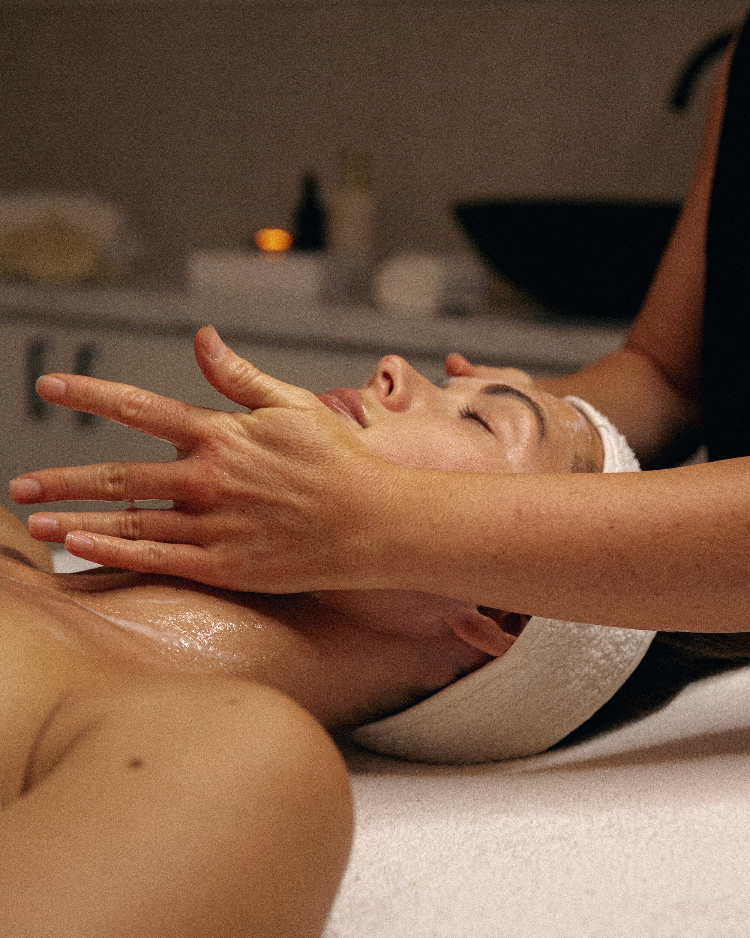 Woman receiving a facial and facial massage from an esthetician, representing a healer’s wellness space supported by a virtual assistant for digital launches, content marketing, SEO, and admin.