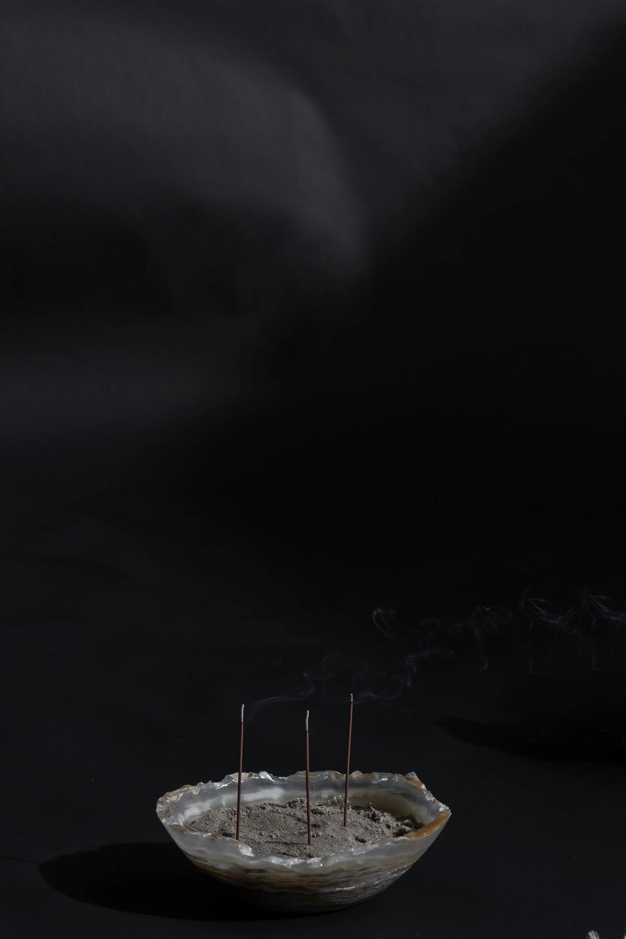 White stone bowl holding lit incense sticks, creating a serene healer workspace supported by virtual assistant services for digital product launches, content marketing, SEO, and admin.