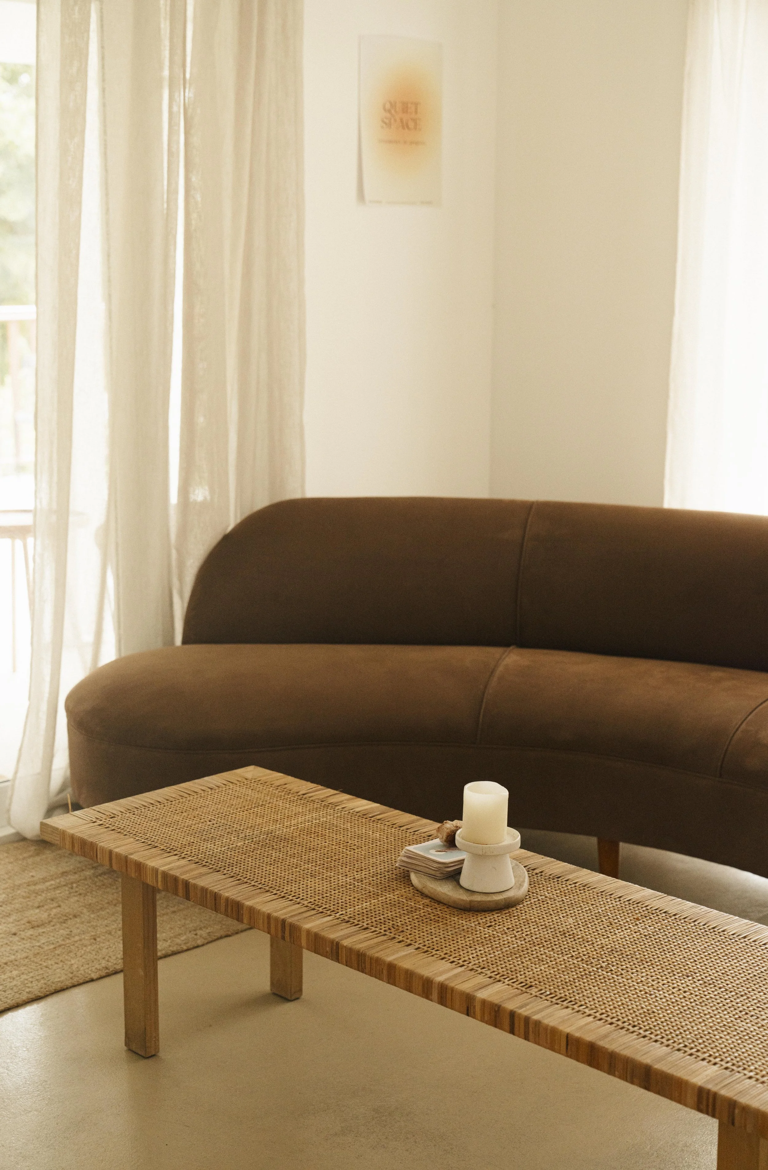 Waiting room with a brown couch and wooden coffee table, representing a healer supported by a virtual assistant for digital product launches, content marketing, SEO, and admin services.