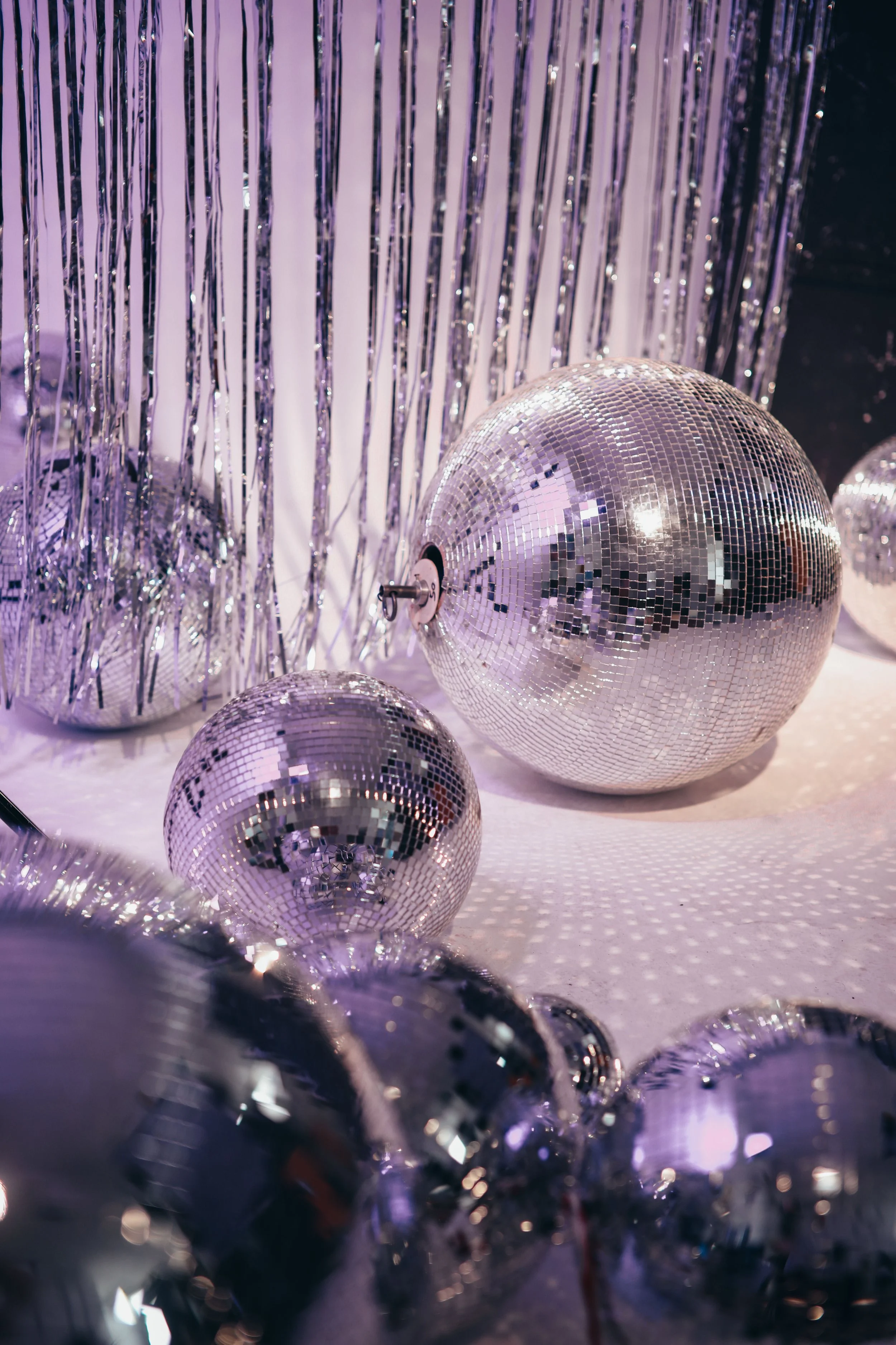 A cluster of disco balls surrounded by silver fringe curtains, representing the payoff of content built on a solid SEO foundation.