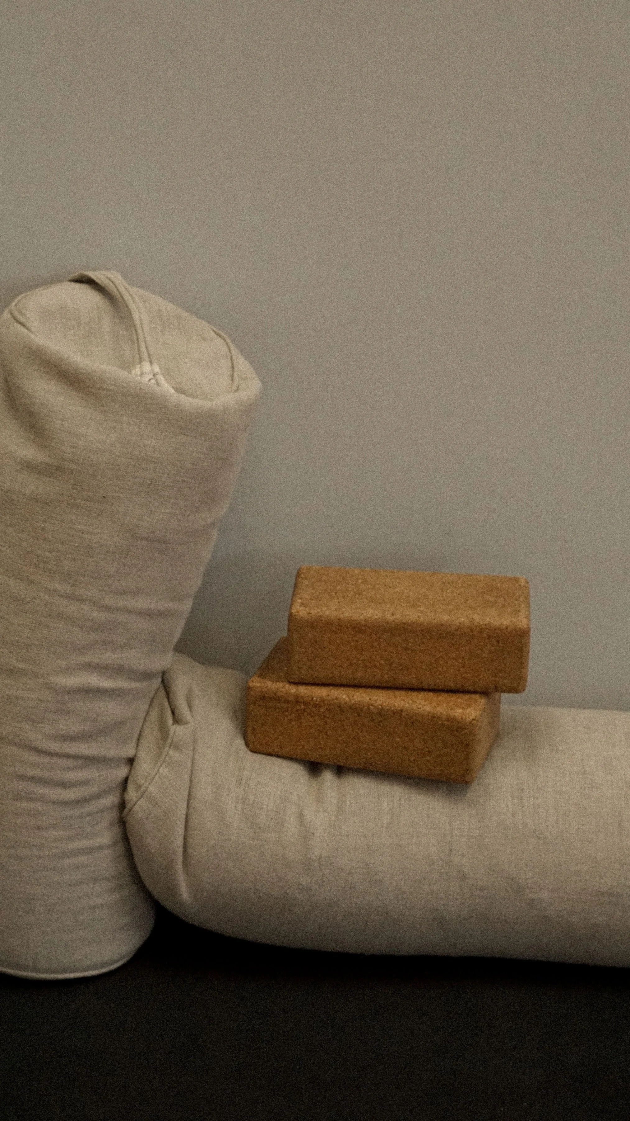Two cream yoga bolsters with cork yoga blocks on top, set in a Pilates studio, representing wellness content created with virtual assistant support for fitness professionals.