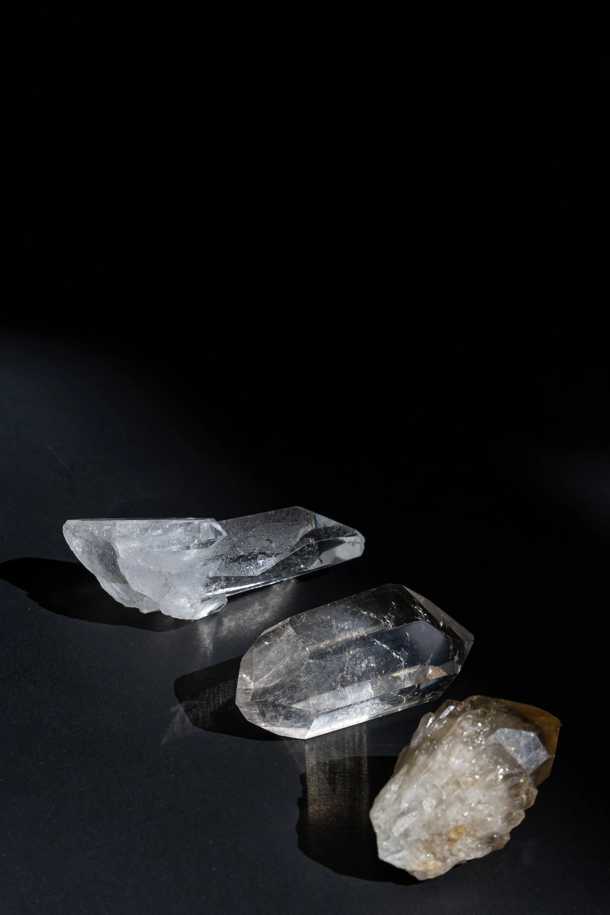 Three crystals arranged against a black background, representing a healer’s wellness practice supported by virtual assistant services for digital product launches, content marketing, SEO, and admin.
