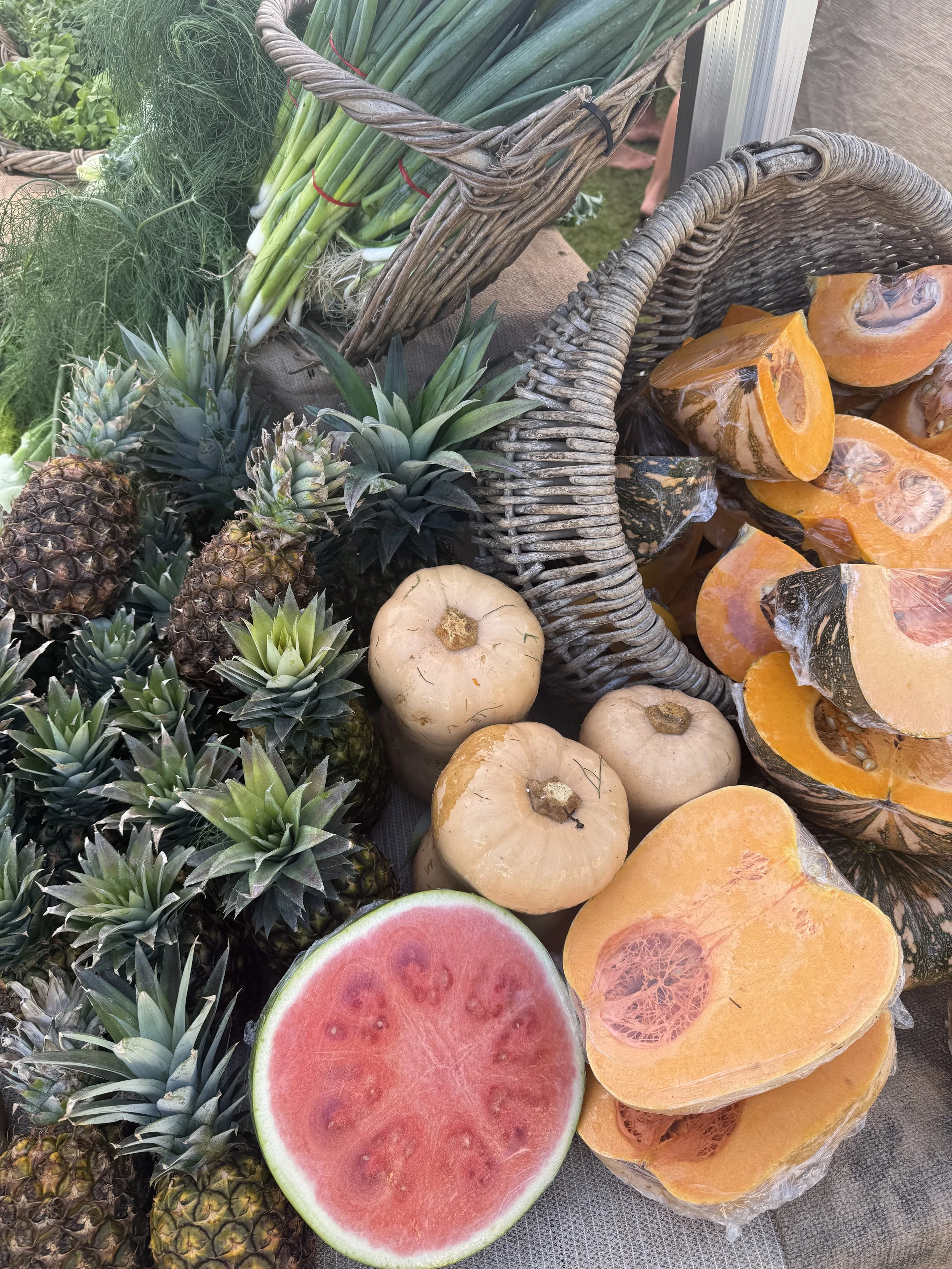 Basket of pineapples and cantaloupes at a local fruit stand, representing healthy food content created with virtual assistant support for nutrition and wellness brands.