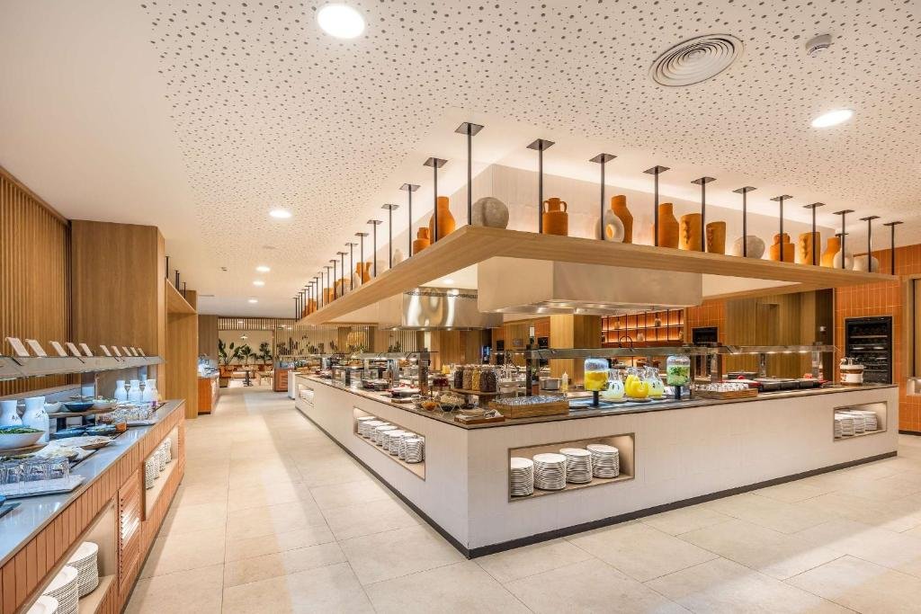 Modernes Buffet-Restaurant mit Holzdekor, Keramiktöpfen und verschiedenen Lebensmitteln auf den Theken.