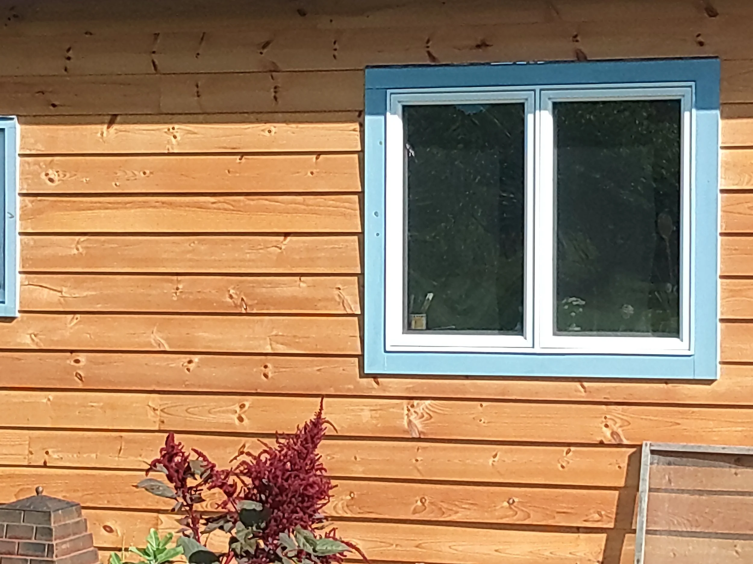 House siding and window trim in brown and blue.