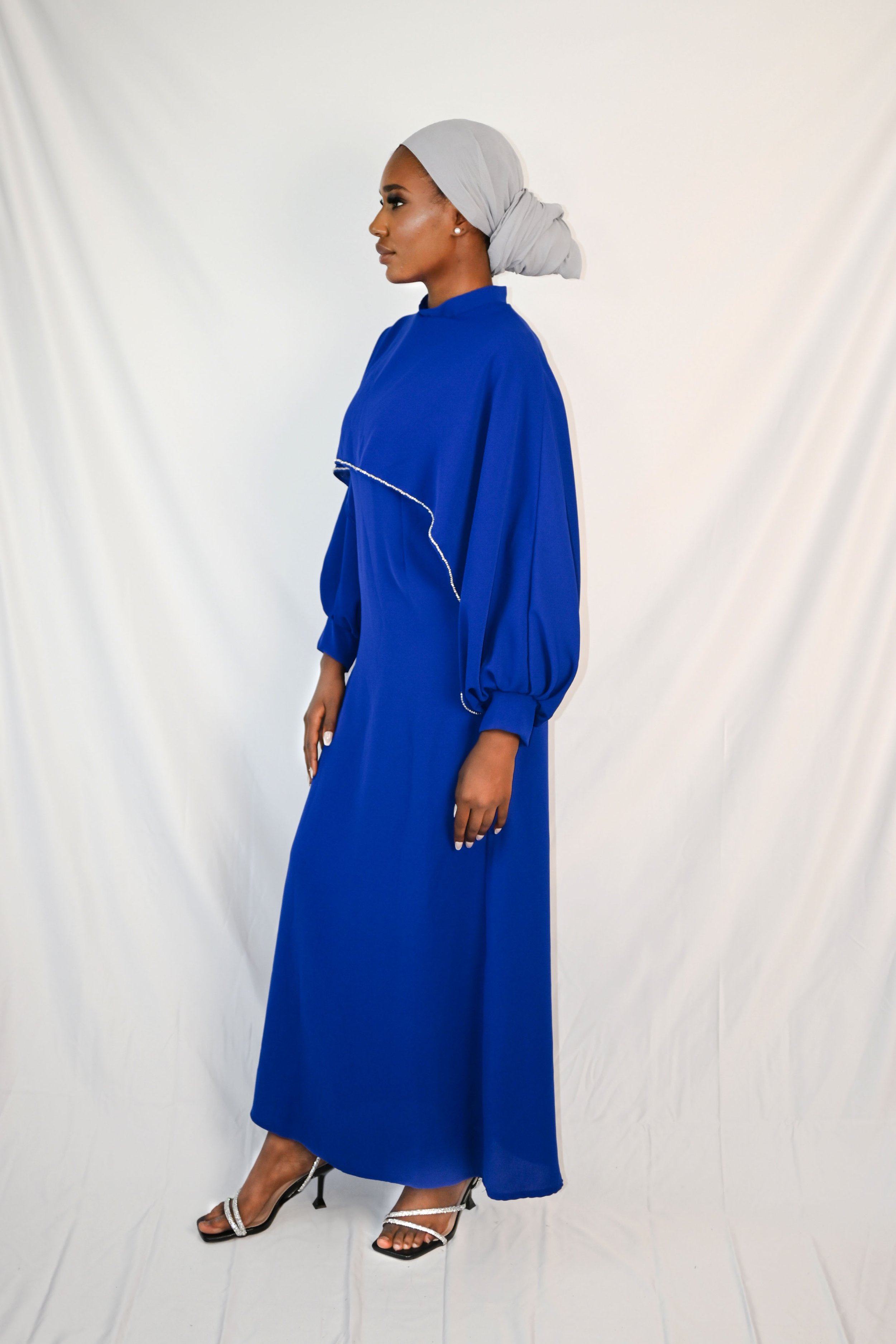 Elegantes blaues Kleid mit funkelnden Strasssteinen, verziert entlang des Saums und der Taille, ideal für glamouröse Abende und festliche Anlässe