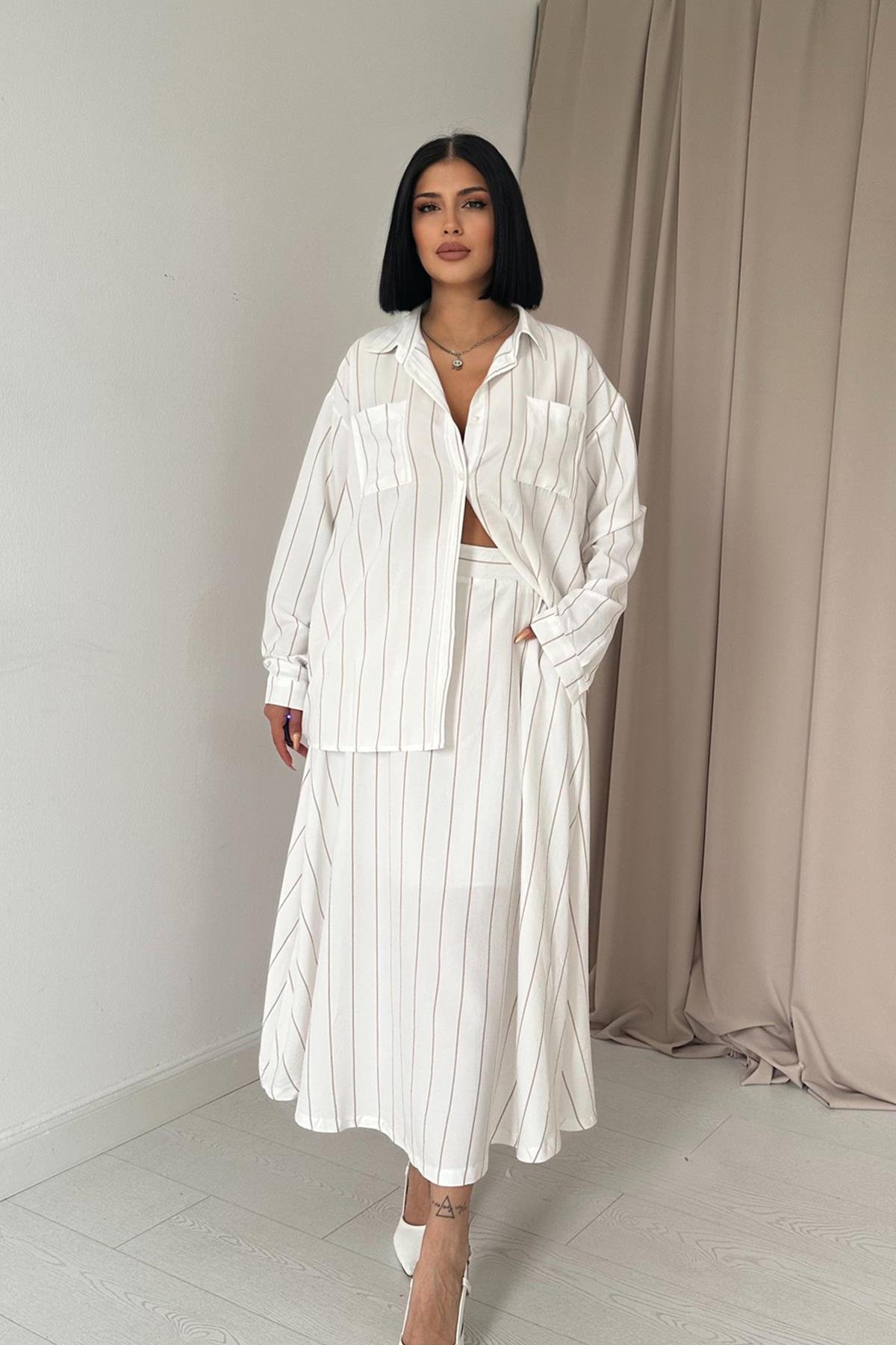 Frau trägt beige-gestreiftes Hemd mit passendem Rock, elegantes Set mit langen Ärmeln und fließendem Schnitt, perfekte Wahl für einen stilvollen, modernen Look.