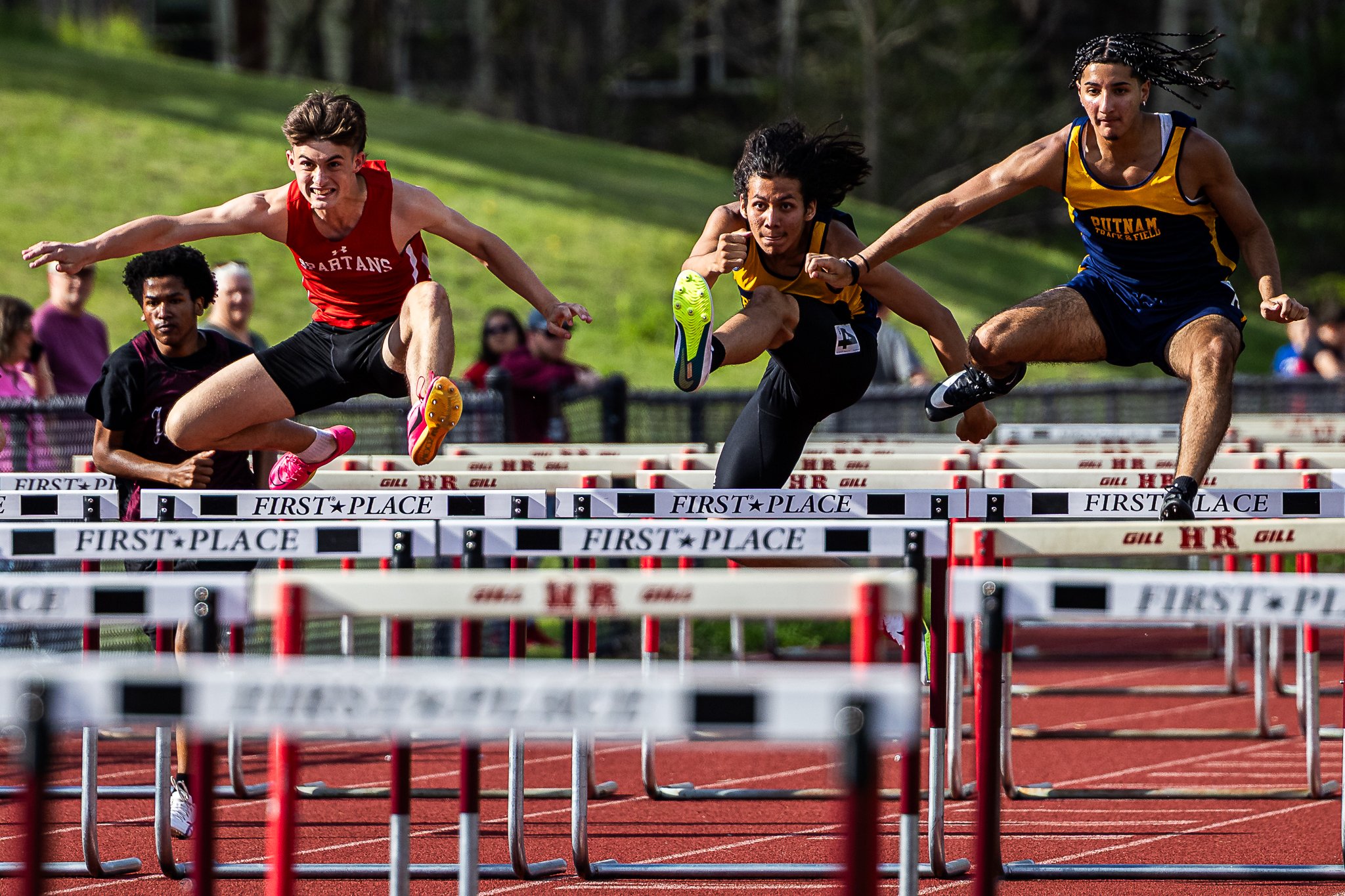 Athletes fly through the air during the 110m hurdles at the Spartan Invitational at Hampshire Regional High School on May 2, 2025.