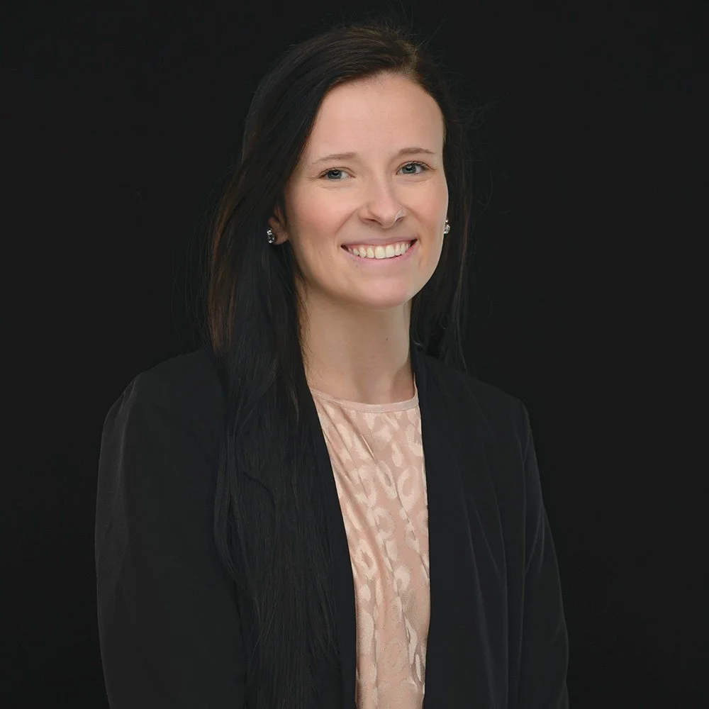 Malee Cook Headshot, smiling at camera against a black background