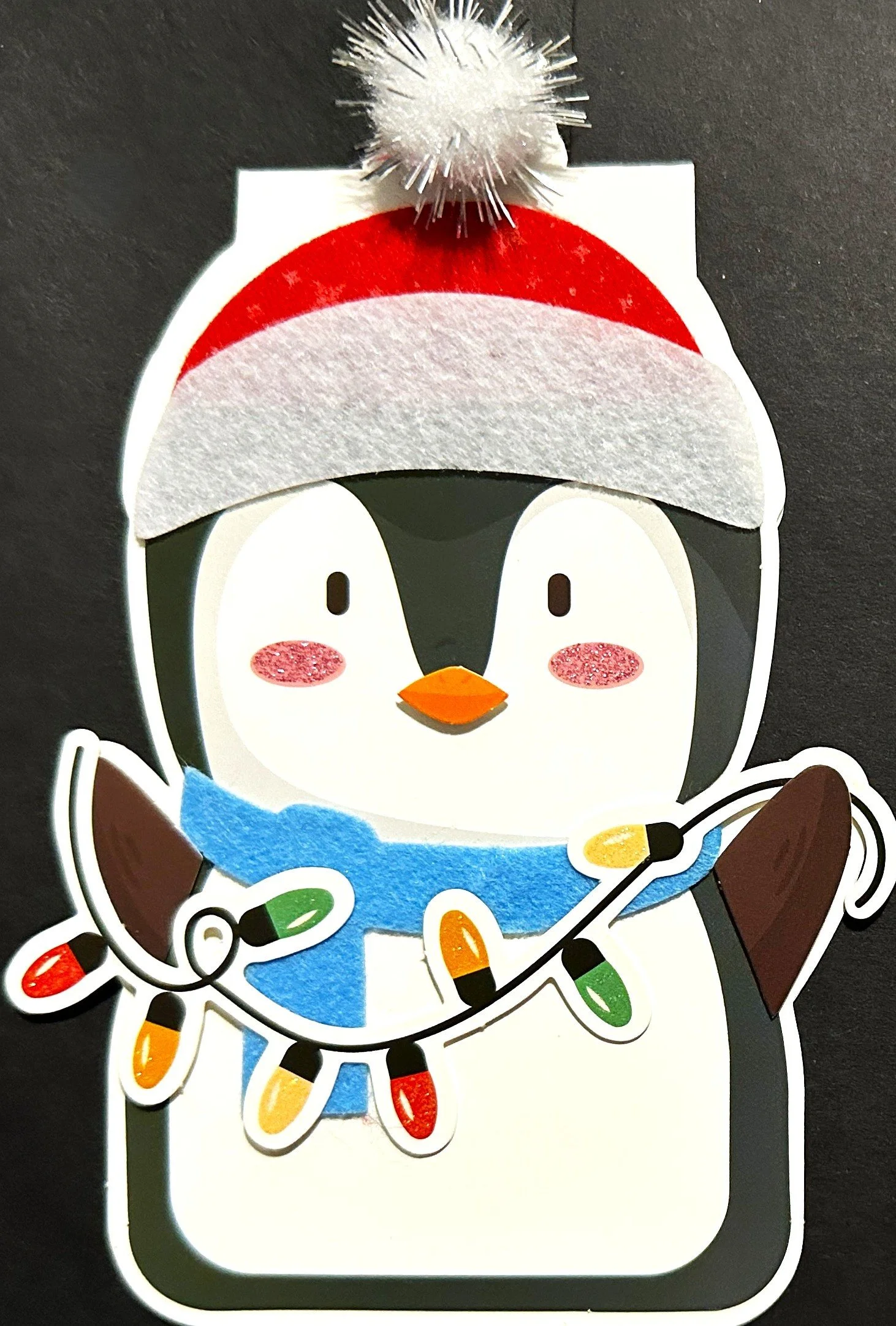 Cute penguin holding a string of Christmas lights