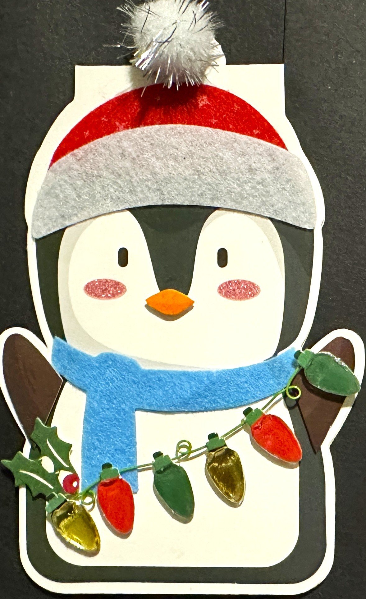 Cute penguin holding a string of lights