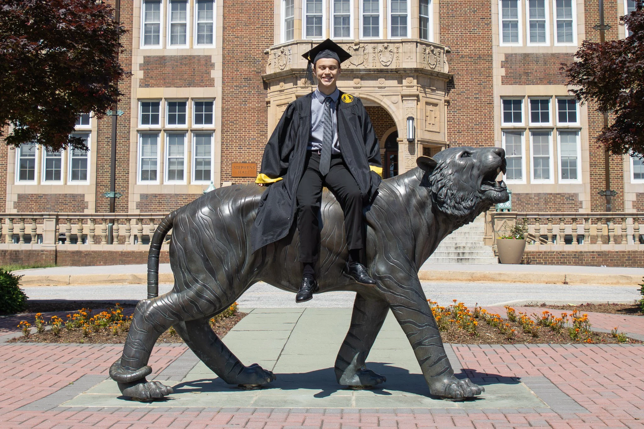 College graduate sitting on the Towson University Tiger