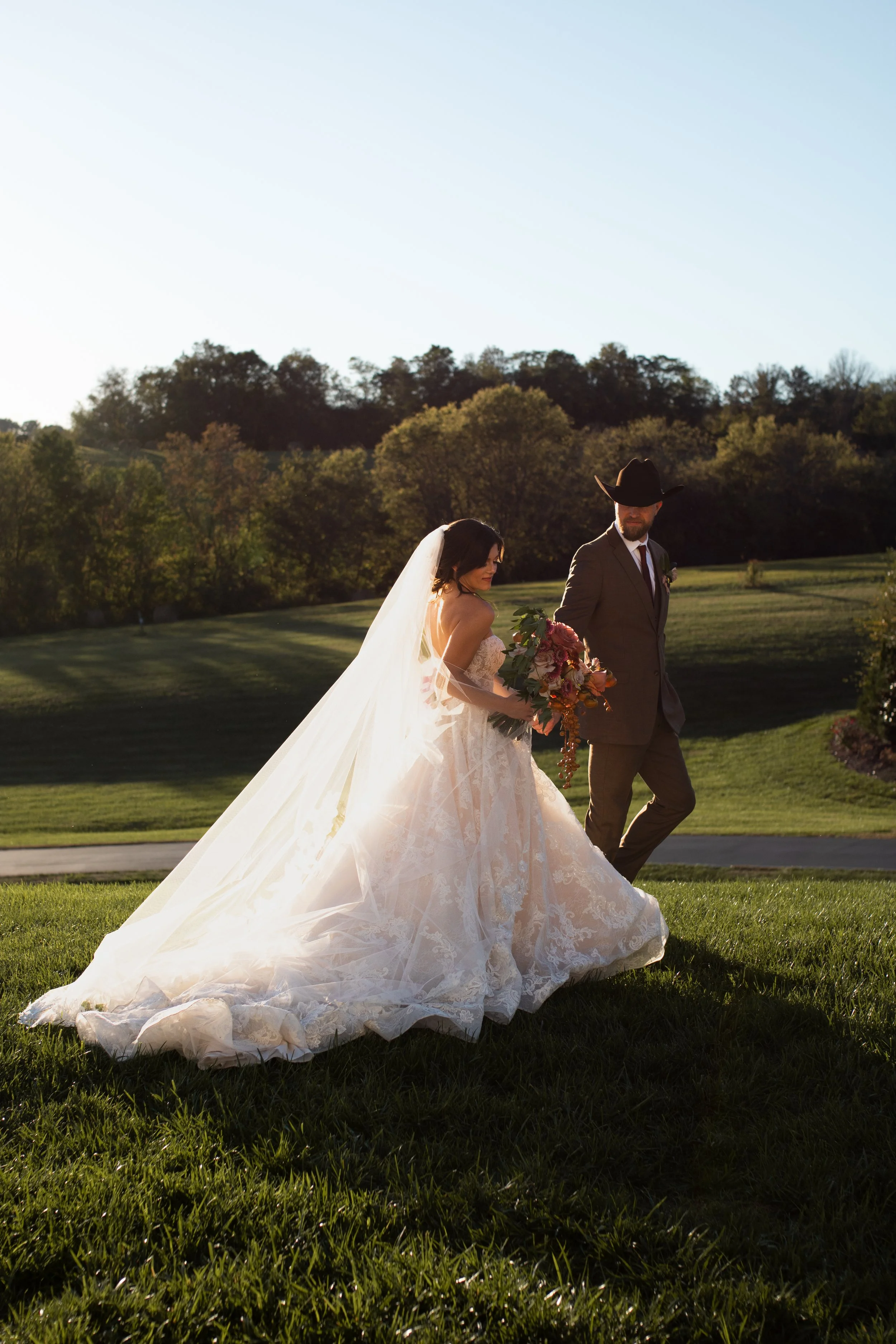 Birmingham wedding photographer captures western wedding outdoors at golden hour with greenery