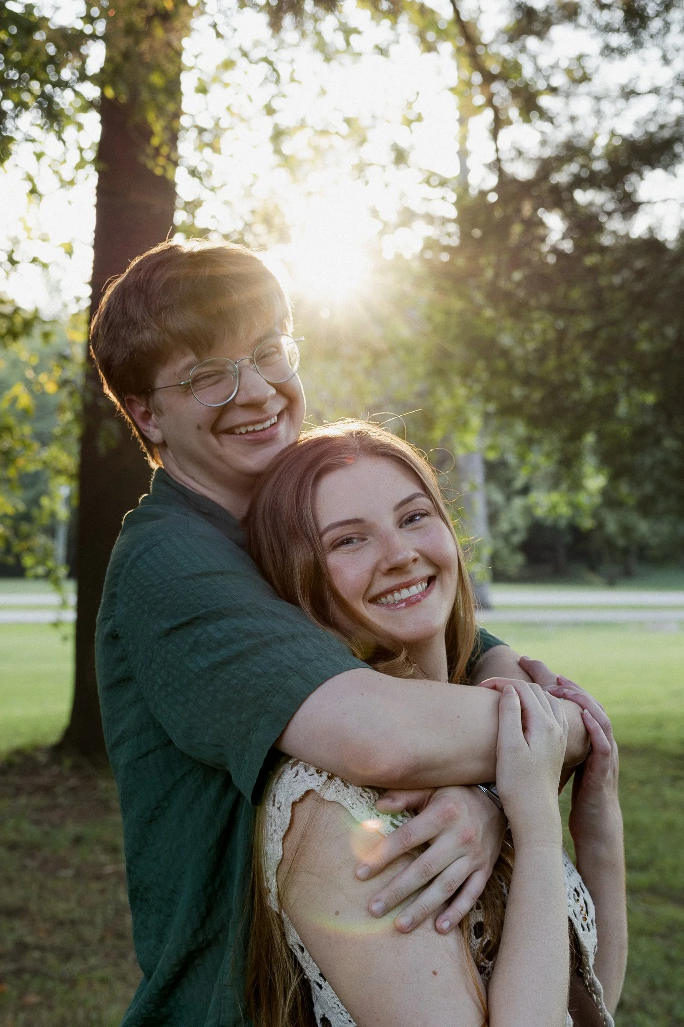 Couple smiling for joyful golden hour portrait outdoors in park setting