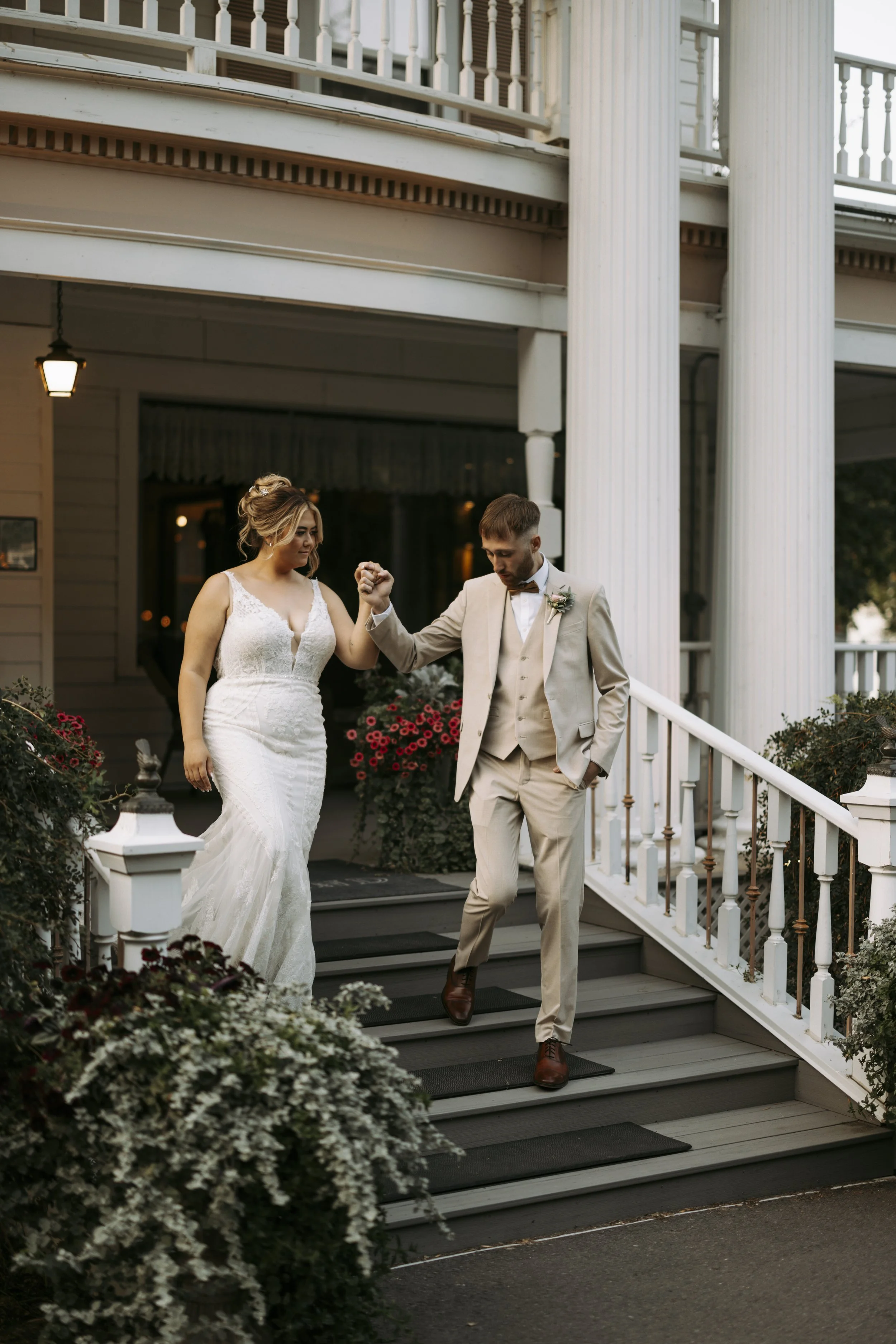 Groom Leads Bride Down a Staircase in The Norland Historic Estate. Lethbridge, Alberta
