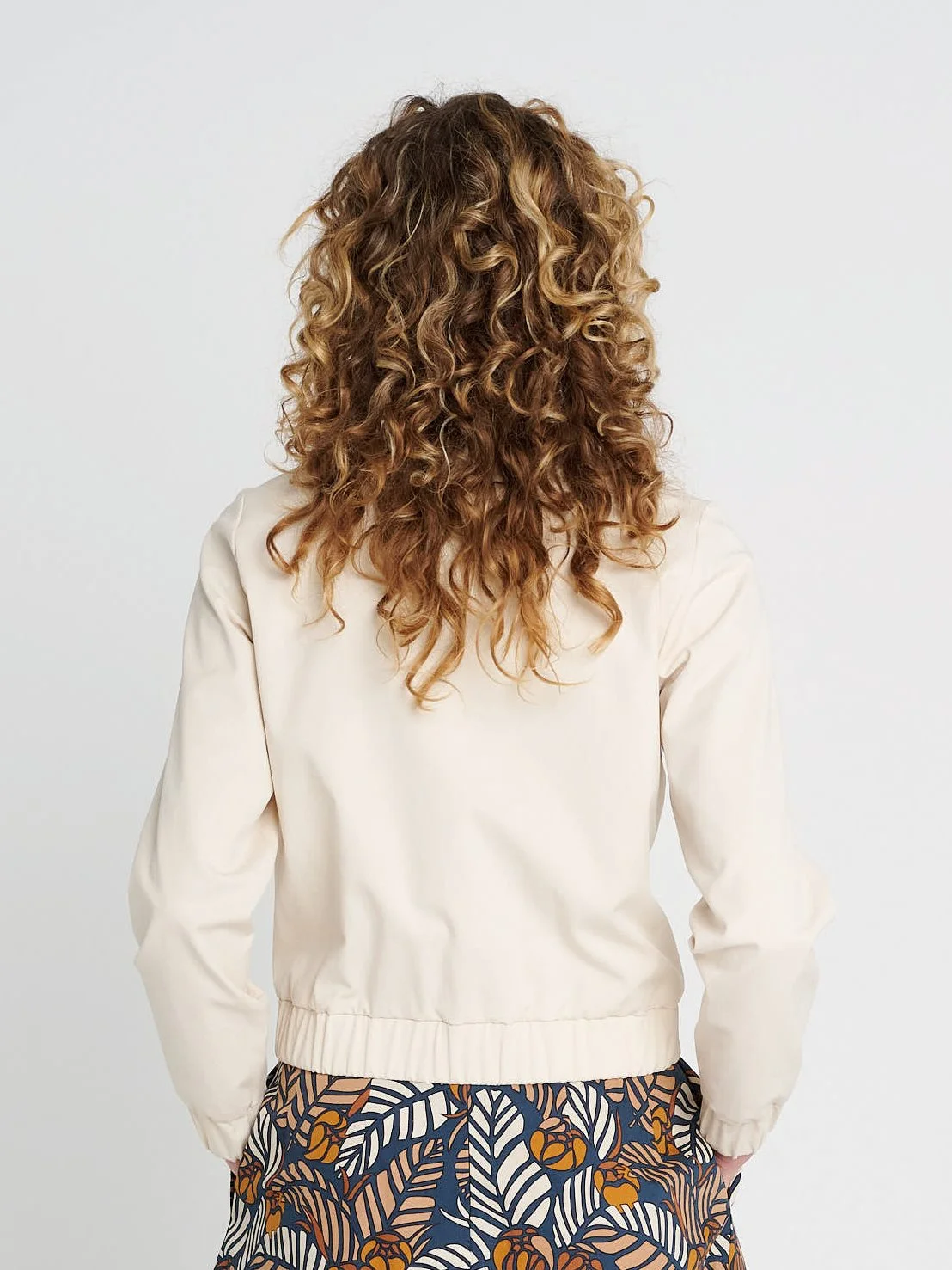 Cremefarbender Blouson mit Kragen, lockere Ärmel und Bündchen aus Lyocell und Baumwolle.