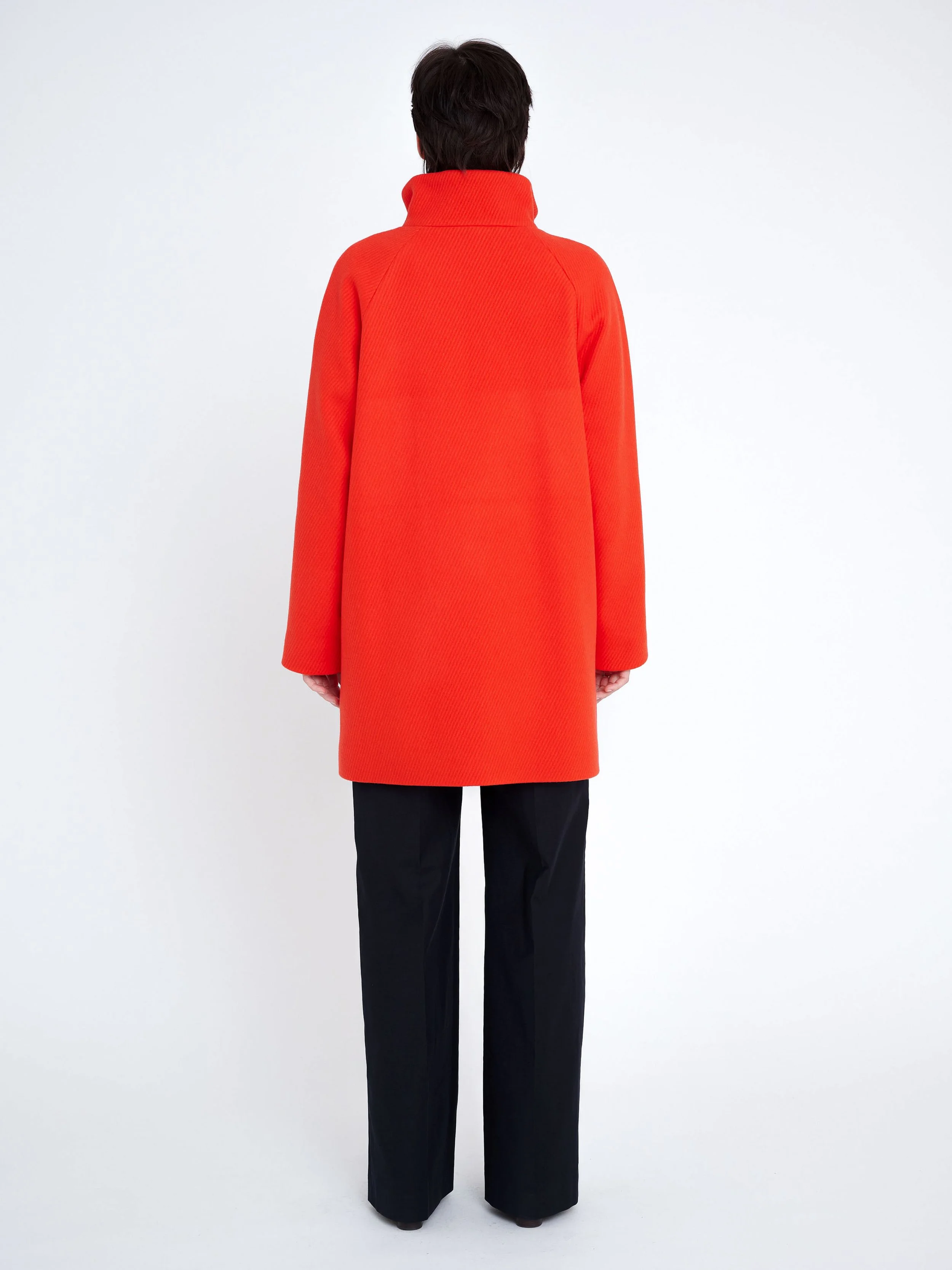 warmer, lockerer, knielanger Designermantel aus korallfarbener Wolle mit Stehkragen und Knöpfen