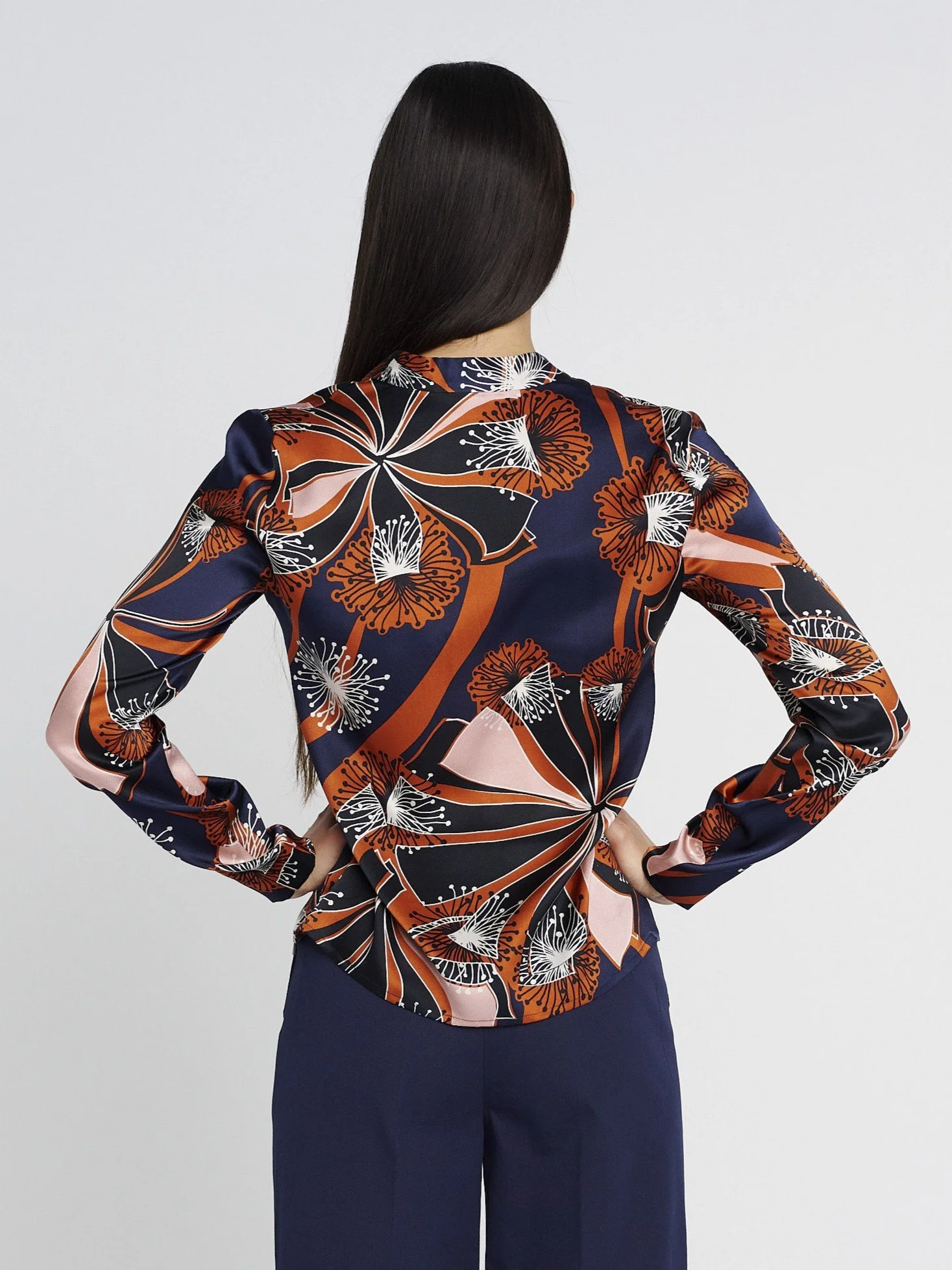 Langärmliche Bluse aus elastischer Seide mit V-Ausschnitt und schmalem Stehkragen, dunkelblau/ orange gemustert.