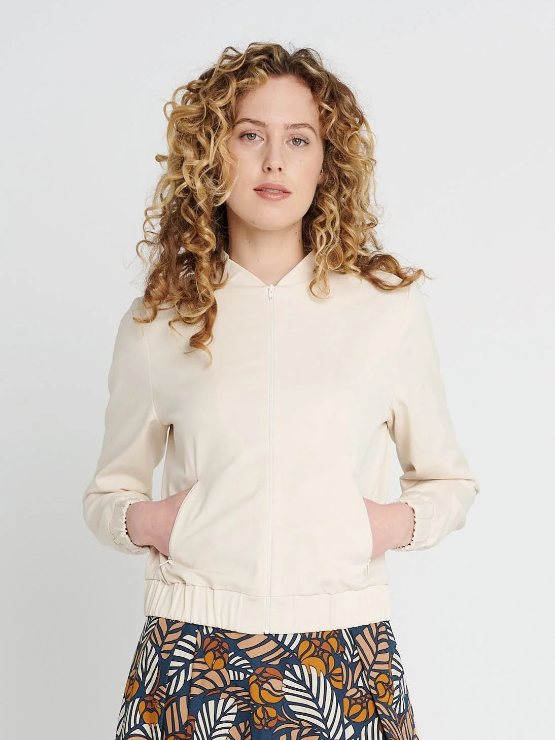 Cremefarbender Blouson mit Kragen, lockere Ärmel und Bündchen aus Lyocell und Baumwolle.