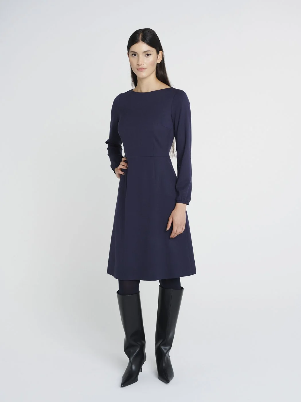 Knielanges, tailliertes Winterkleid aus dunkelblauer Schurwolle, weiter Rock und Rundhalsausschnitt.