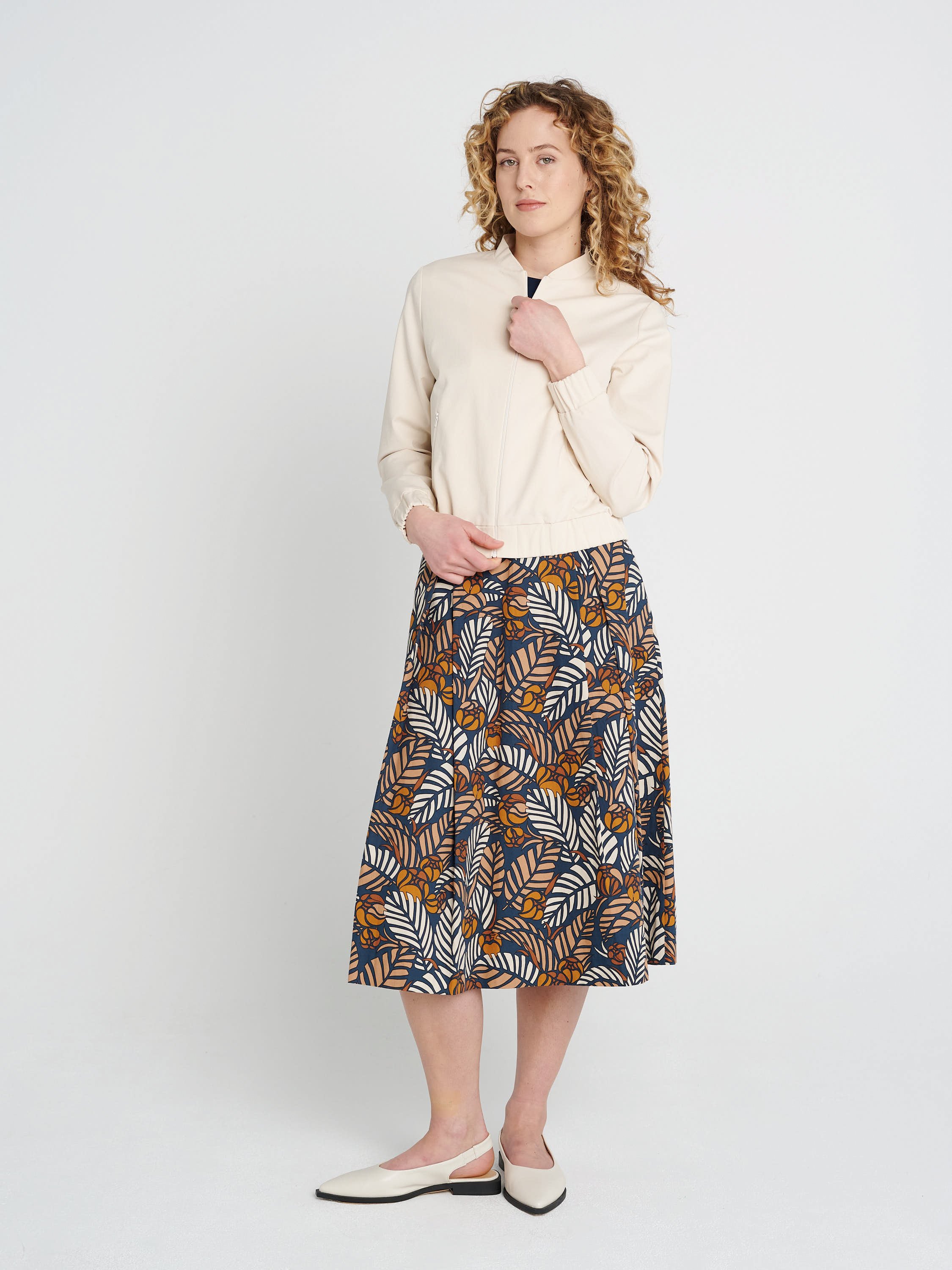 Cremefarbender Blouson mit Kragen, lockere Ärmel und Bündchen aus Lyocell und Baumwolle.