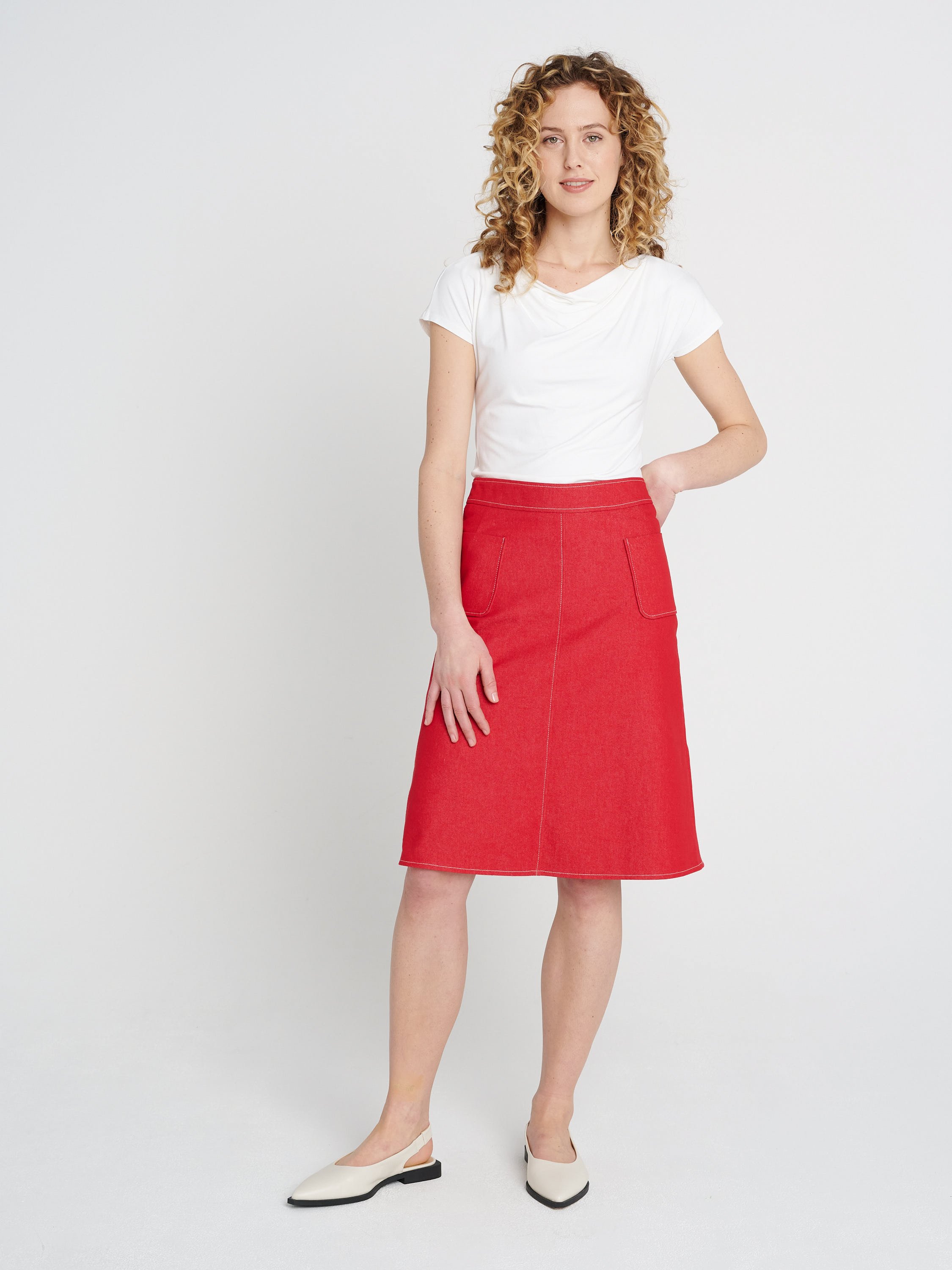 Roter knielanger Jeansrock aus Baumwolle mit weitem Saum, breitem Bündchen und Taschen.