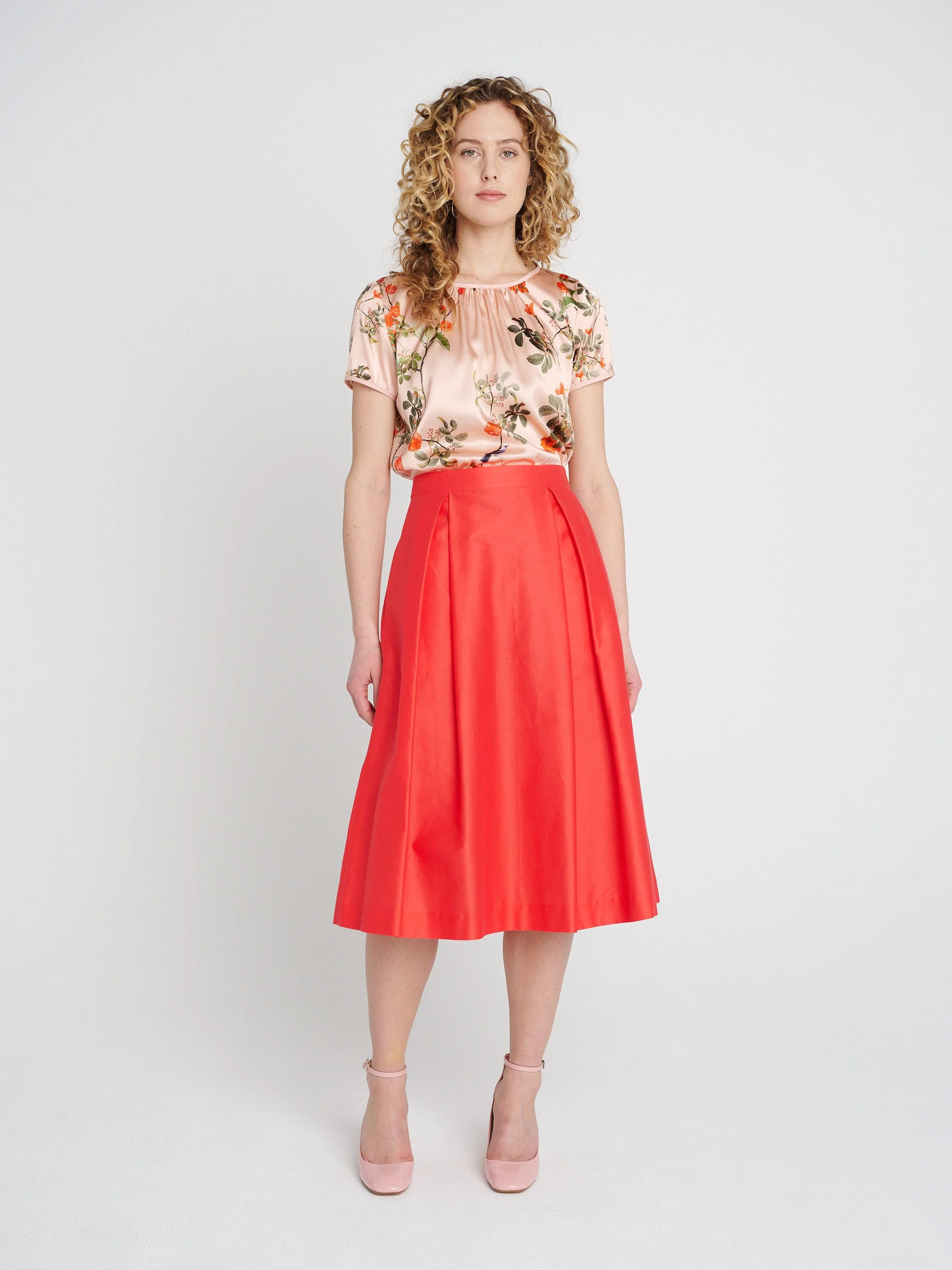 A-Liniger Sommerrock in orange-pink mit Taschen und Kellerfalten, halblang.