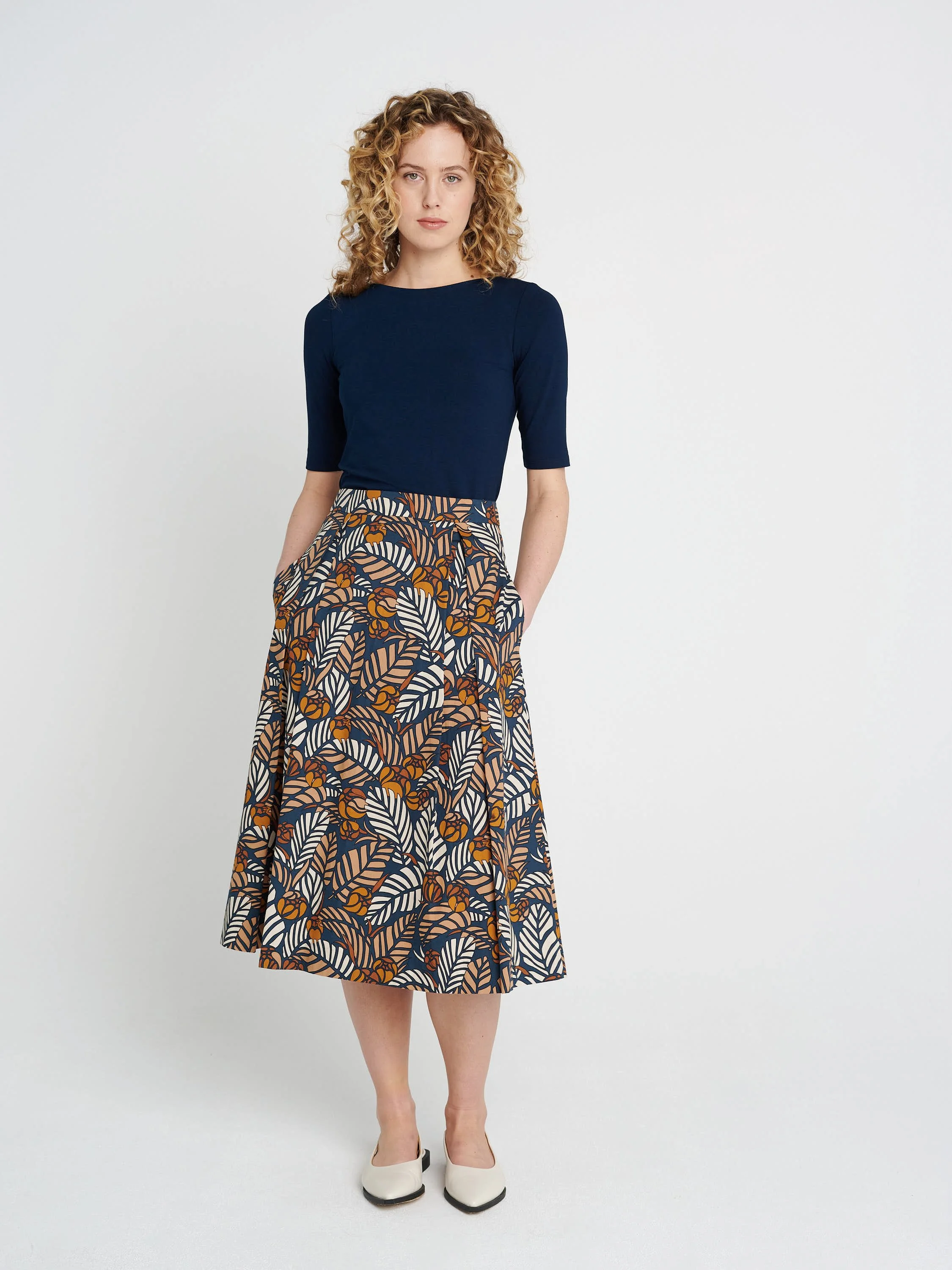 Moderner Faltenrock in Midi-Länge, schmale Bündchen und ausgestellter Saum aus blau/ braun/ gemusterter Baumwolle.