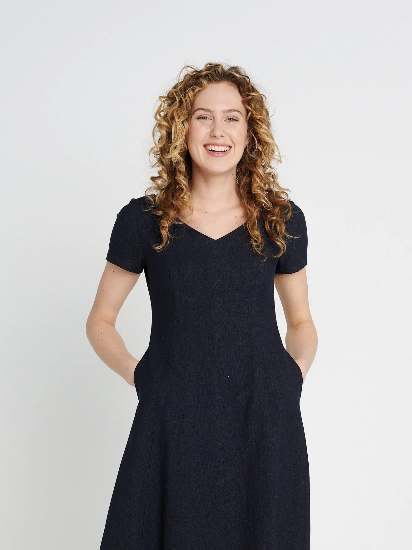 Tailliertes Kleid mit weitem Rock und Teilungsnähten mit V-Ausschnitt aus weichem, elastischem Jeansstoff, dunkelblau.