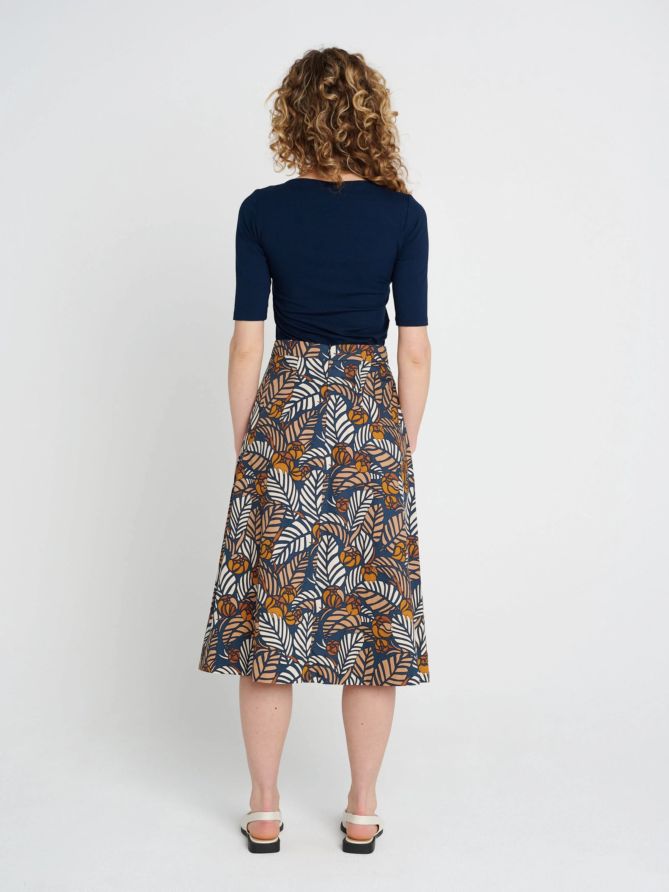Moderner Faltenrock in Midi-Länge, schmale Bündchen und ausgestellter Saum aus blau/ braun/ gemusterter Baumwolle.