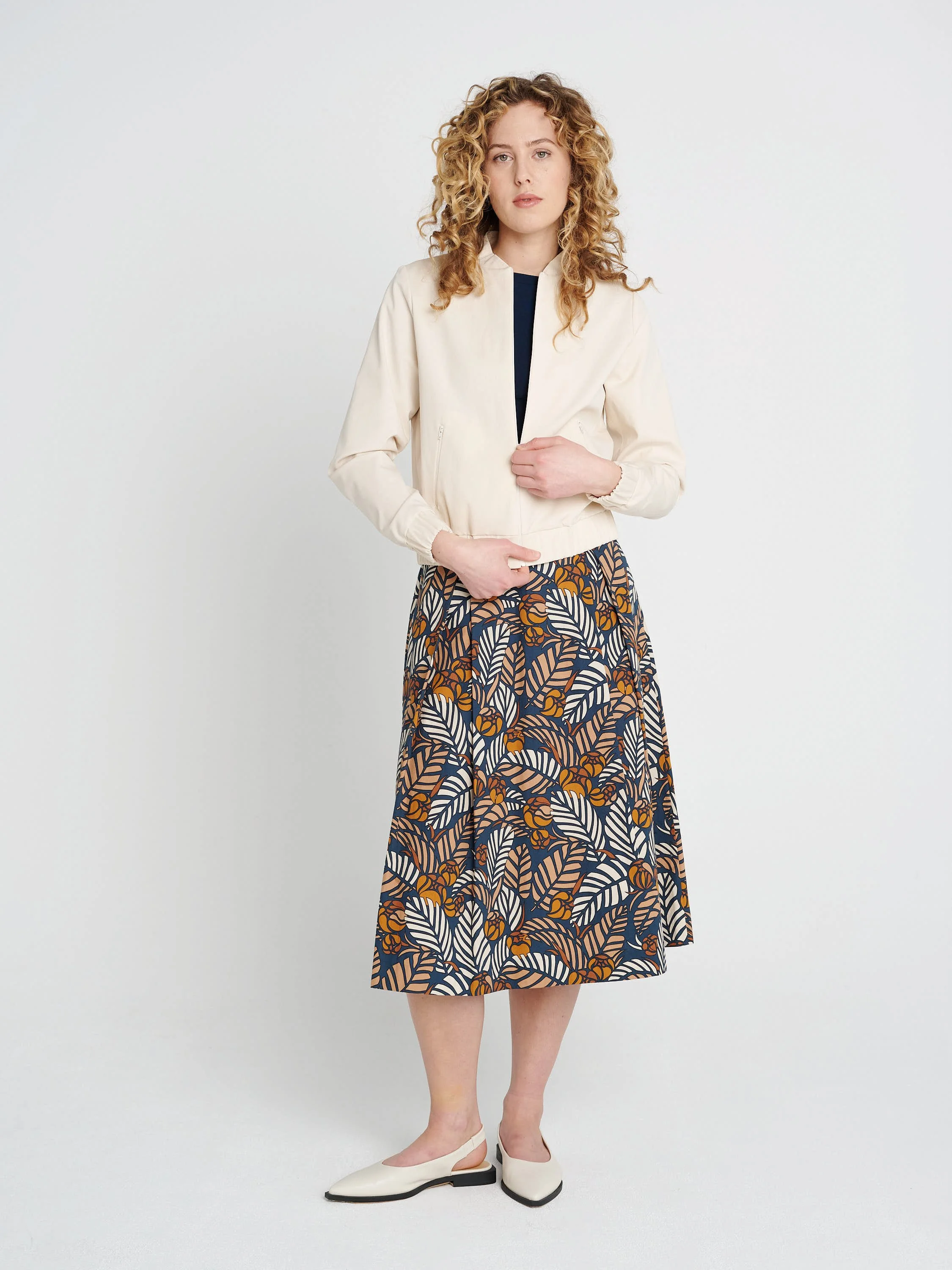 Cremefarbender Blouson mit Kragen, lockere Ärmel und Bündchen aus Lyocell und Baumwolle.